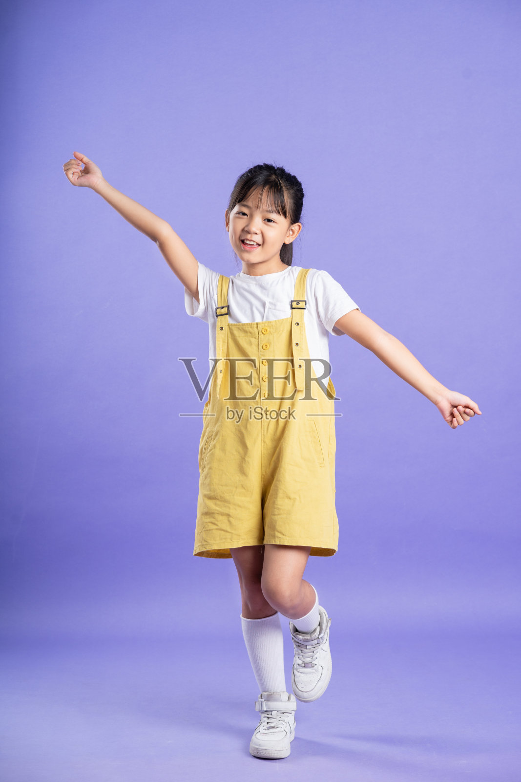 可爱的亚洲女婴在紫色背景上摆姿势照片摄影图片