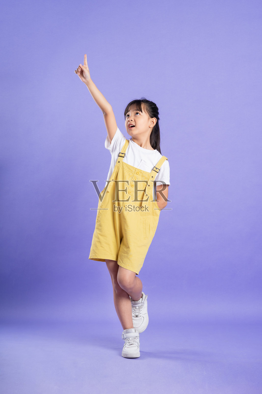 可爱的亚洲女婴在紫色背景上摆姿势照片摄影图片