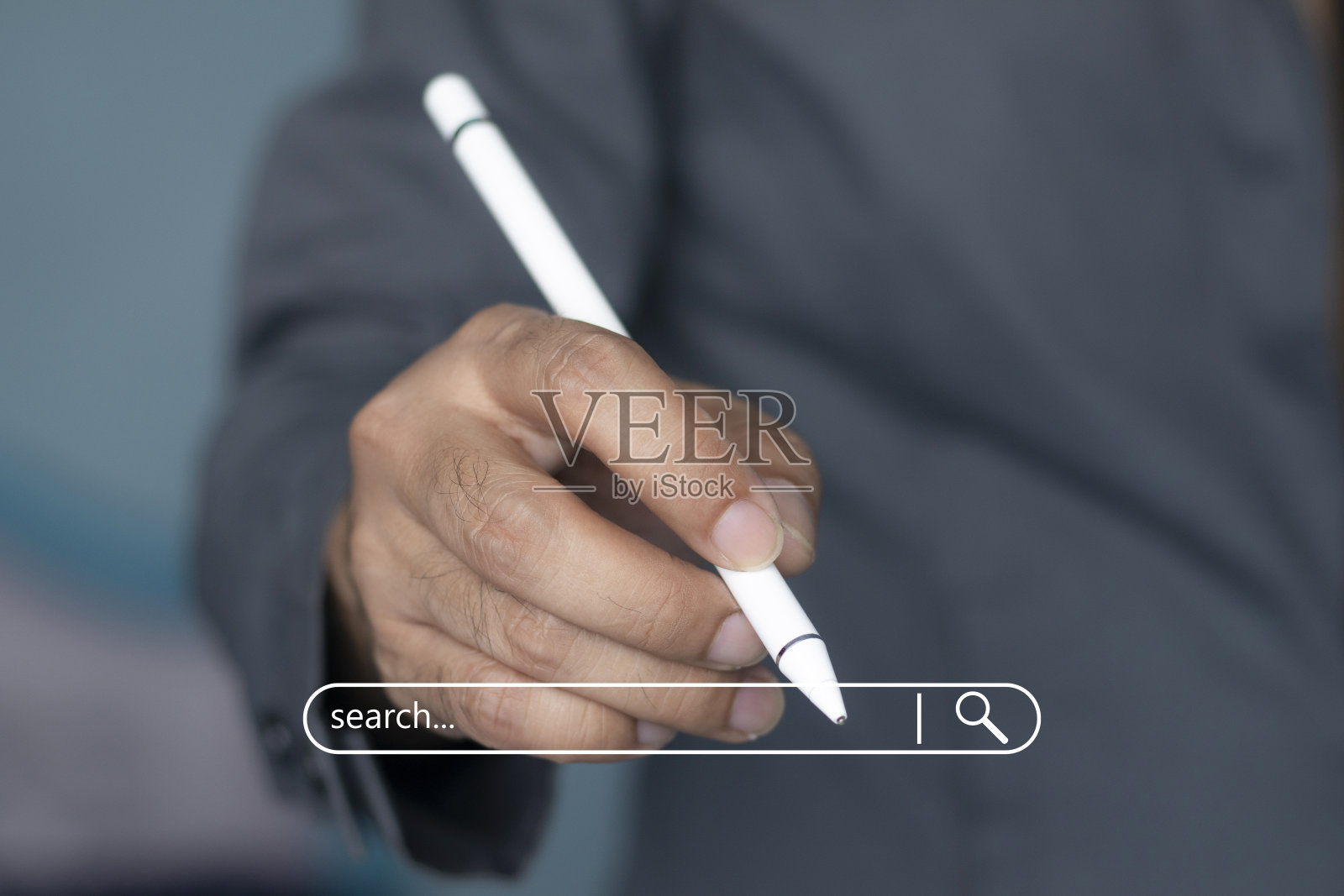 一个穿着西装的男人手里拿着一支白色的笔照片摄影图片