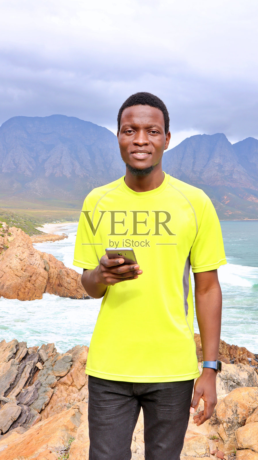 年轻的非洲黑人男子使用手机和智能手表照片摄影图片