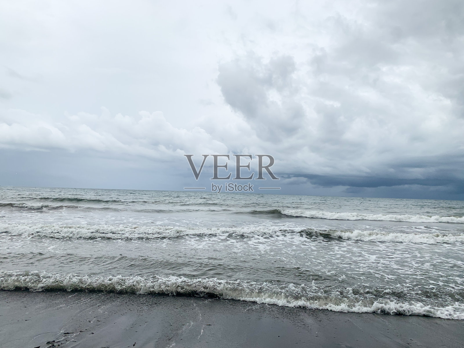 海浪的海滩，阴天。照片摄影图片