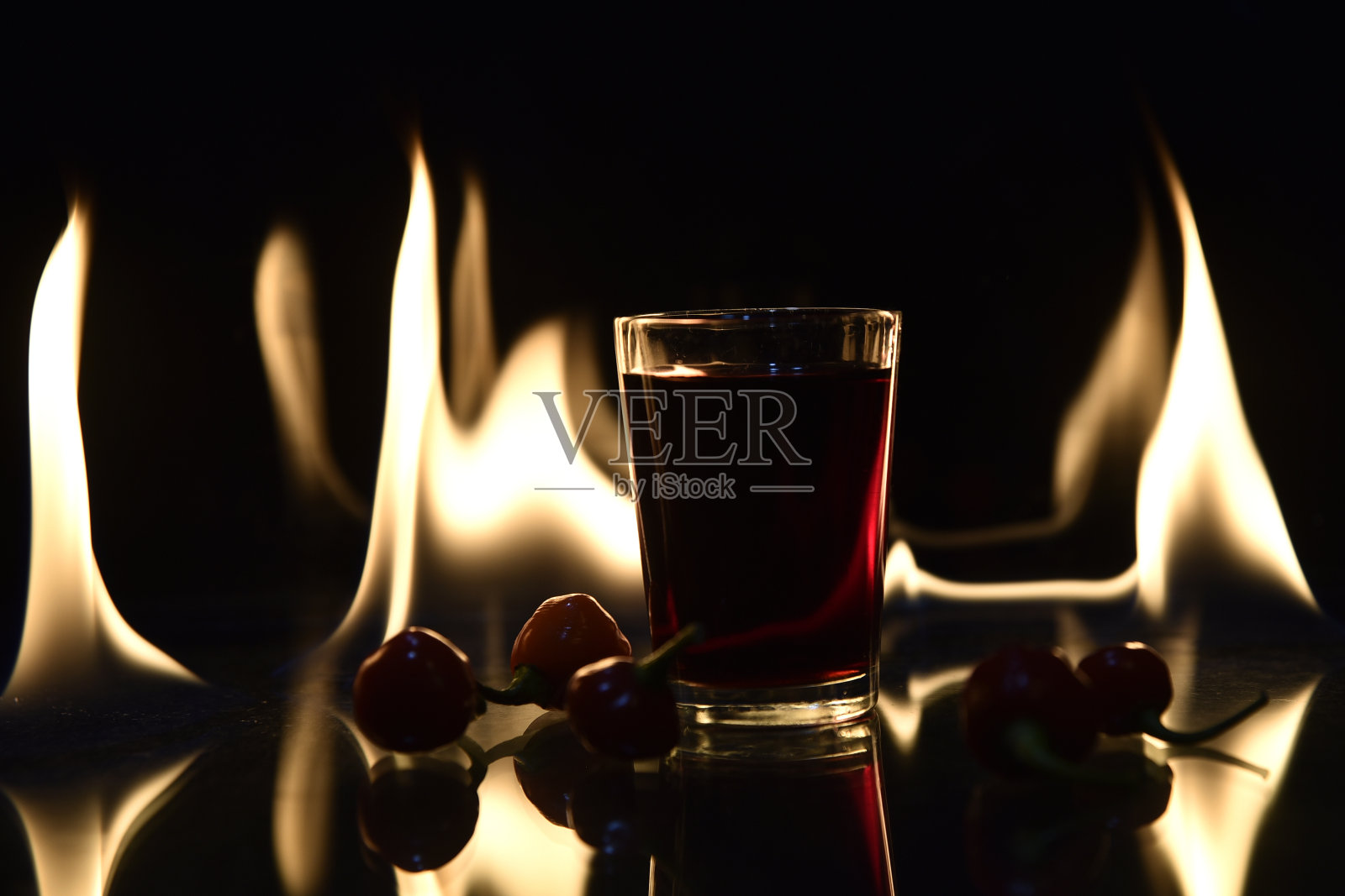 镜头的饮料与火的背景与反射饮料红辣椒热的形象照片摄影图片