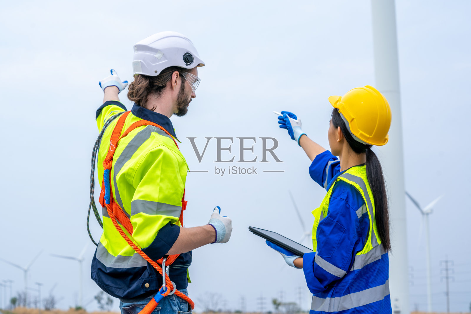 在风力发电机组工作和维护的工程师。照片摄影图片