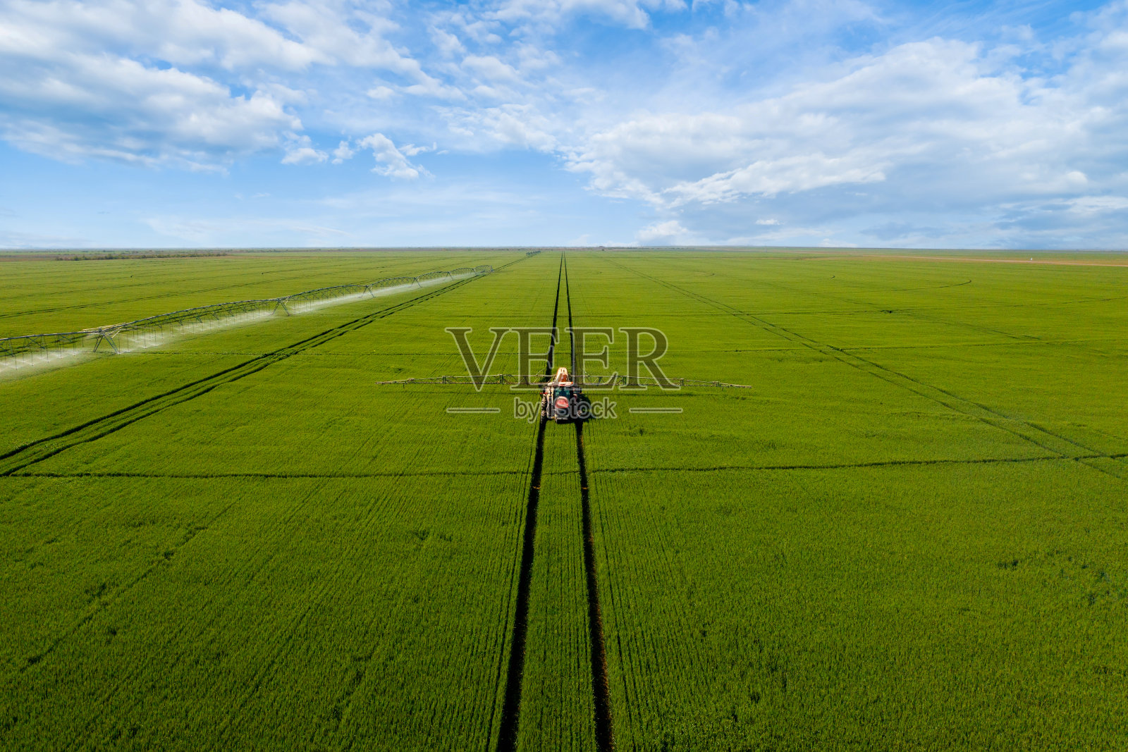 拖拉机在绿地上喷洒肥料鸟瞰图。照片摄影图片