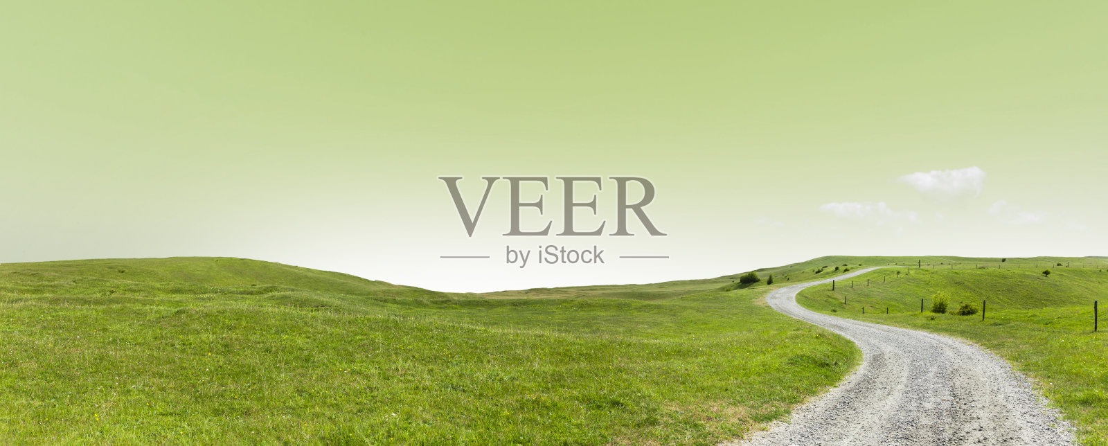 前进的道路穿过一片绿色的丘陵景观照片摄影图片