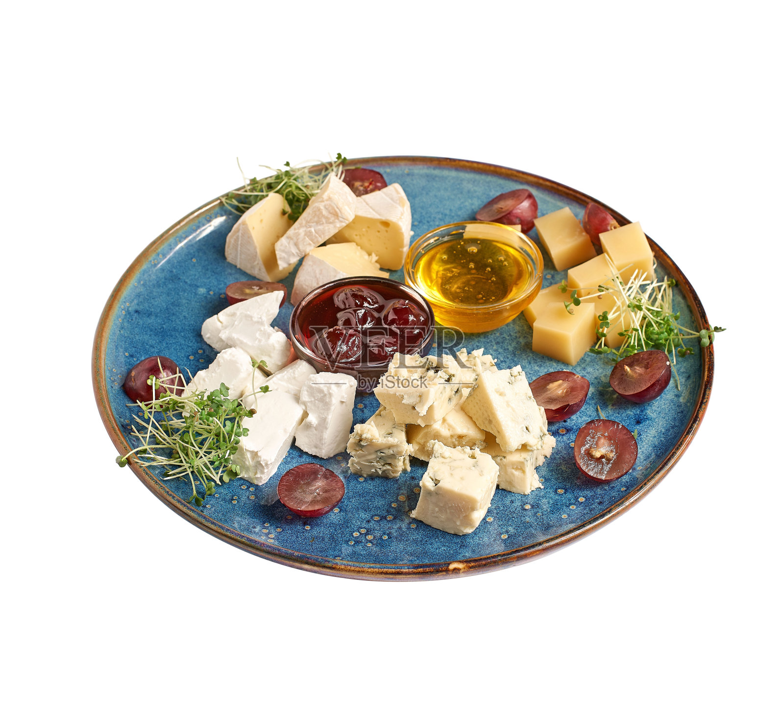 奶酪拼盘与蜂蜜，坚果和红葡萄在餐馆盘子孤立。照片摄影图片