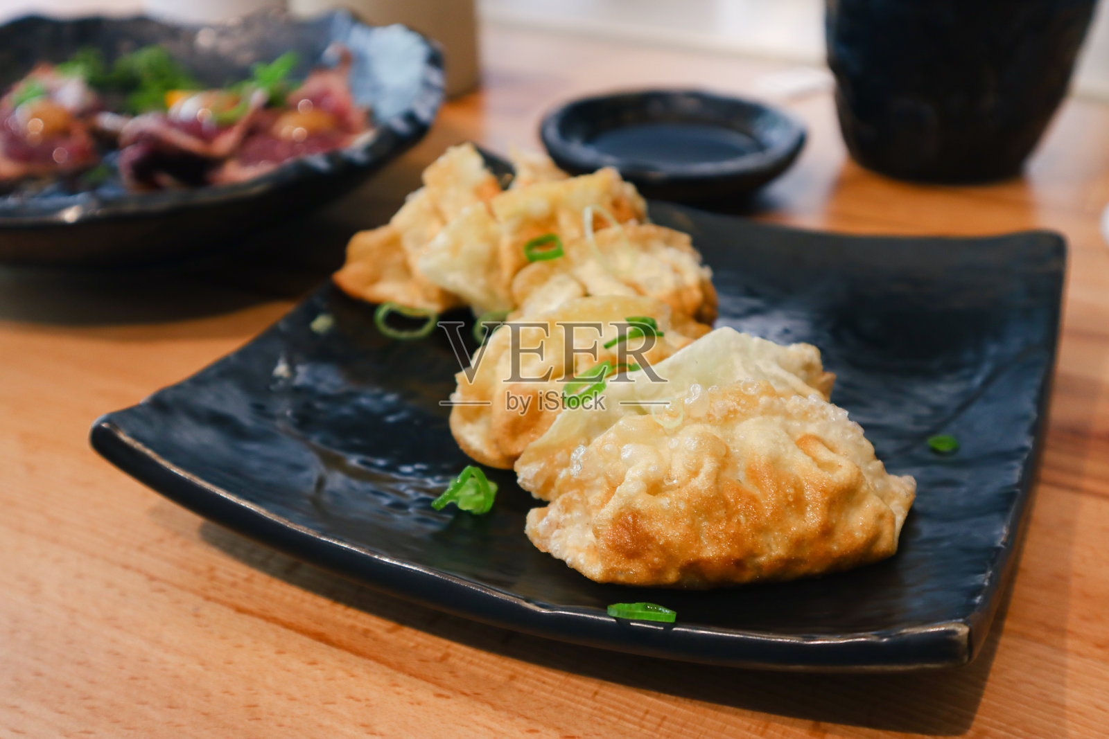 桌上有一盘用老抽煎的日本饺子照片摄影图片