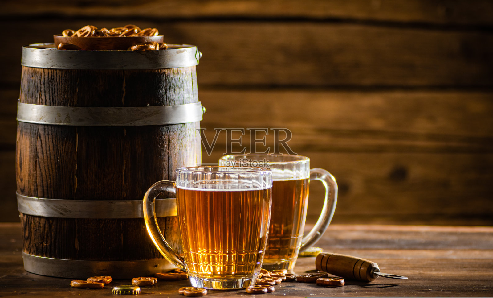 用玻璃杯盛啤酒，配上盐脆饼。照片摄影图片