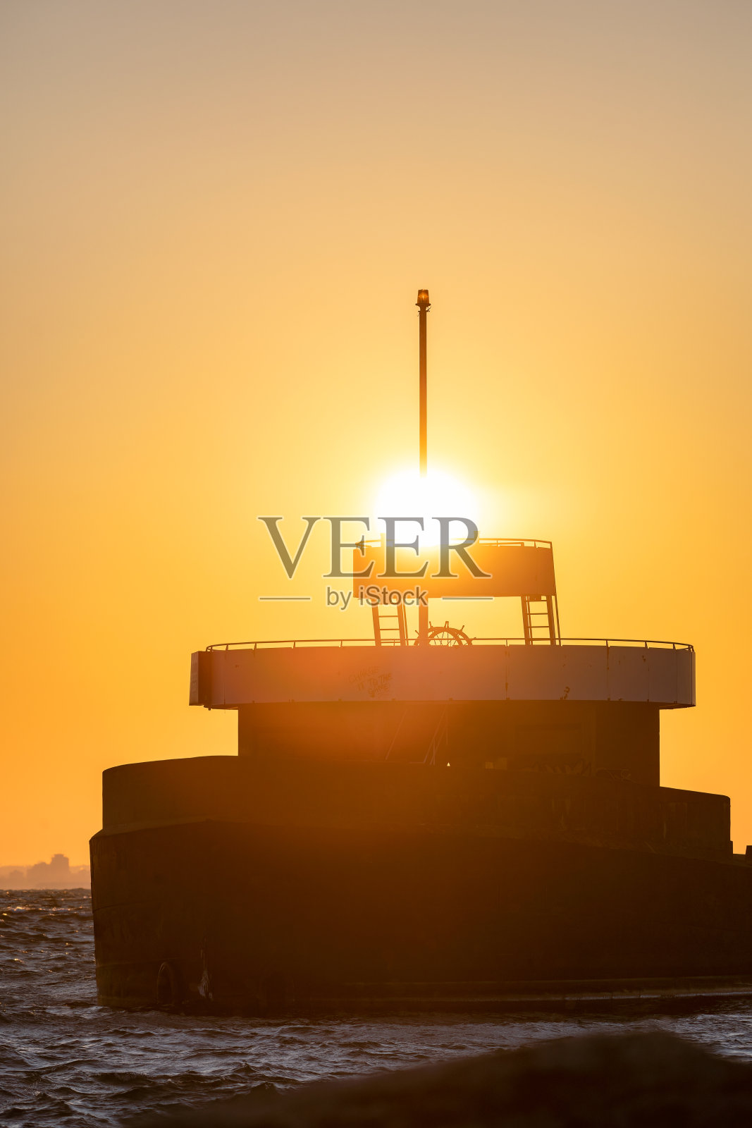 在一艘船的剪影后面，充满活力的夕阳照片摄影图片
