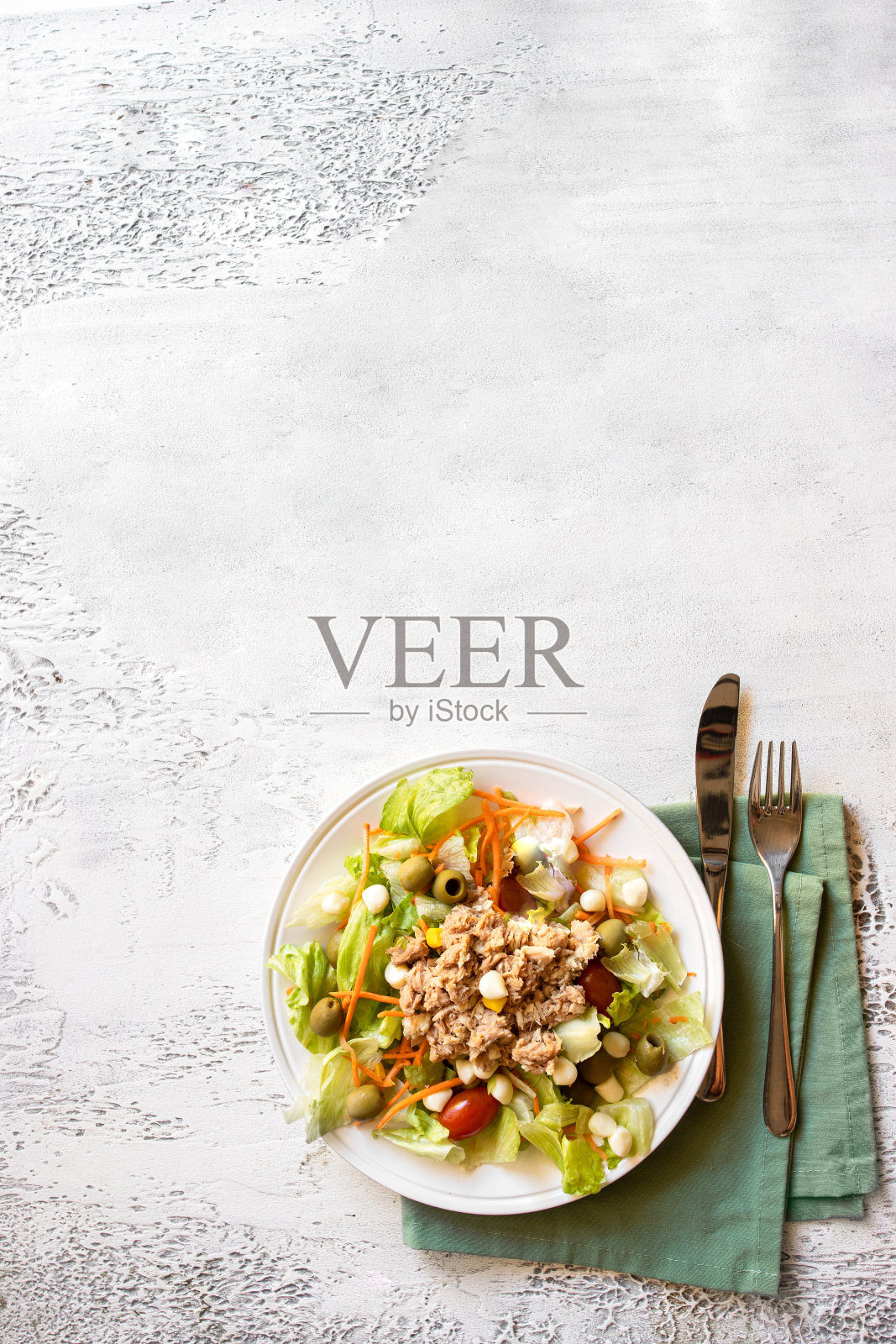 白色混凝土背景上的金枪鱼沙拉，有生菜、西红柿、胡萝卜和玉米。本空间照片摄影图片