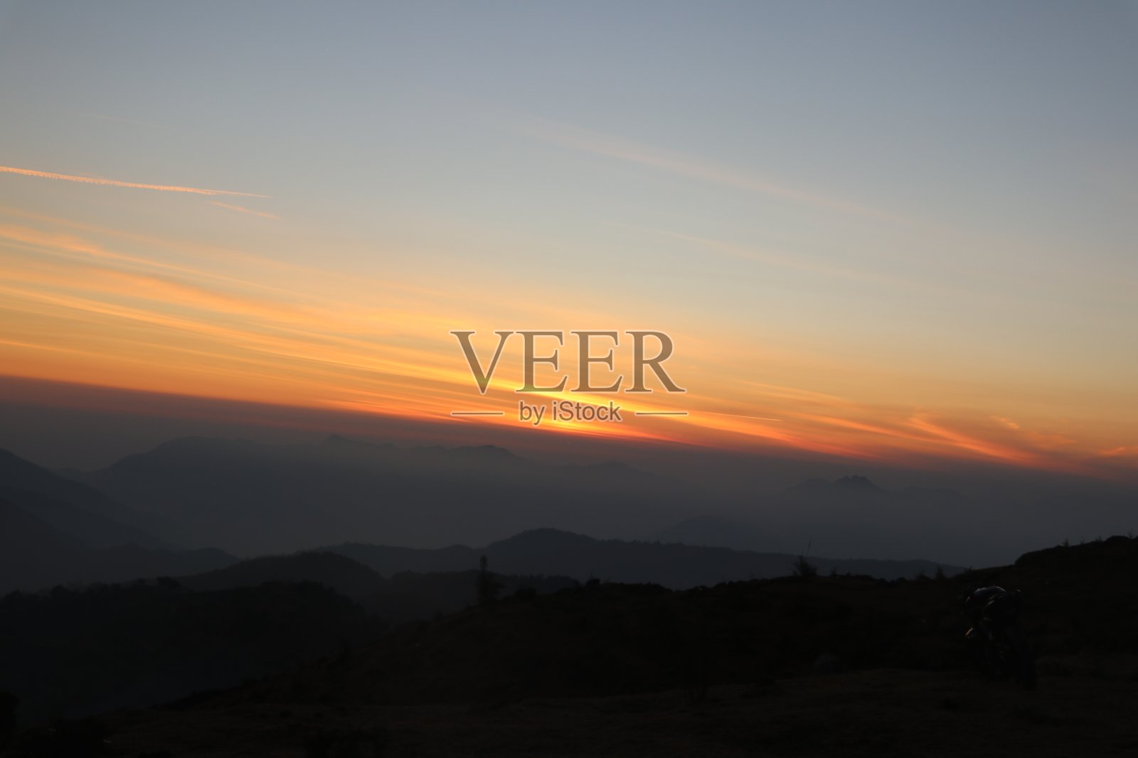 山顶的日落，早晨有雾。照片摄影图片