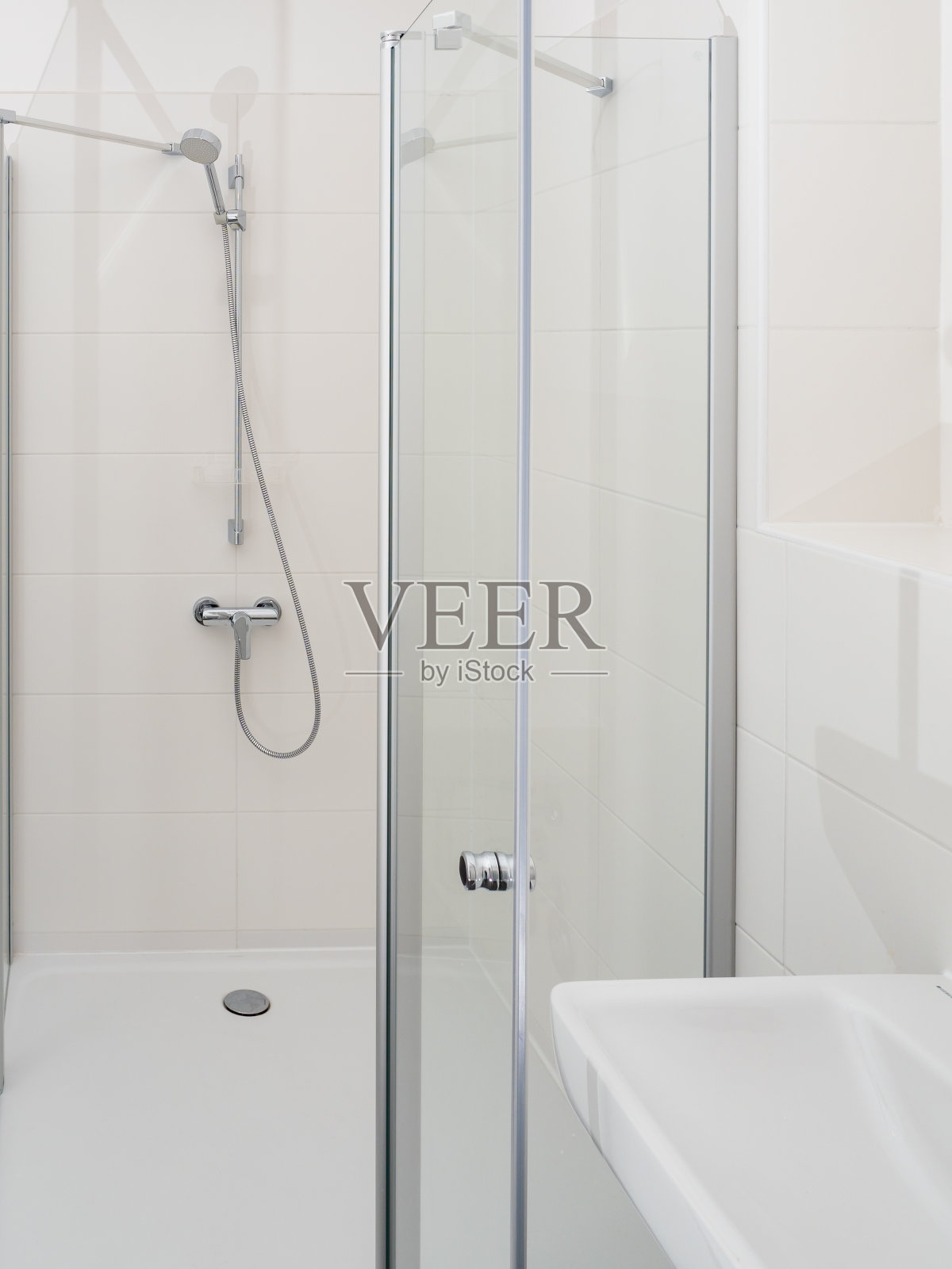 淋浴房配有镀铬水龙头，透明玻璃门和架子。照片摄影图片