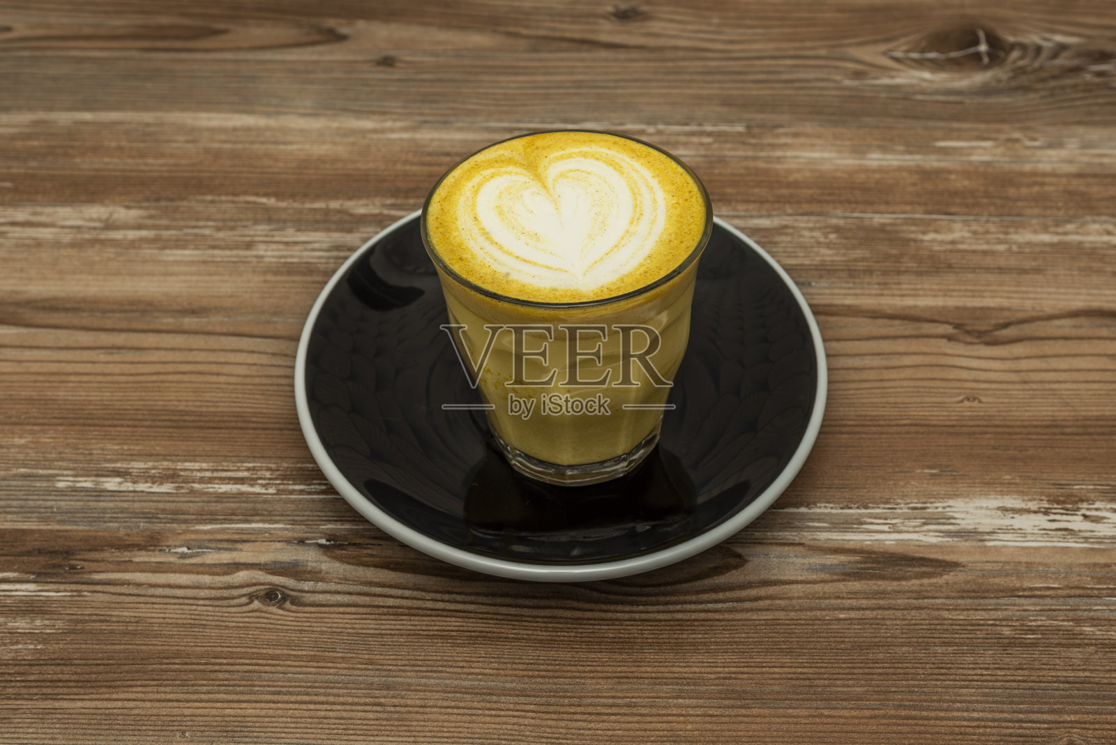 用姜黄、肉桂、可可、姜、胡椒和其他香料制成的;被称为金色拿铁，因为它的泡沫和明亮的黄色，分层的温暖和美味的味道照片摄影图片