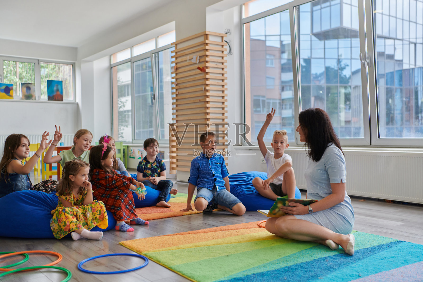 小学或幼儿园的阅读时间，老师给小学或幼儿园的孩子们读一本书。学前教育的概念。有选择性的重点照片摄影图片