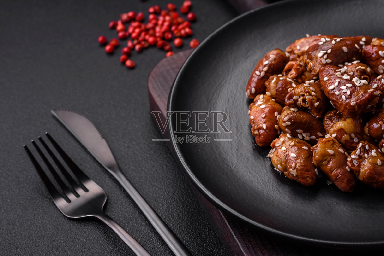 用盐和香料炒鸡心，放在盘子里照片摄影图片