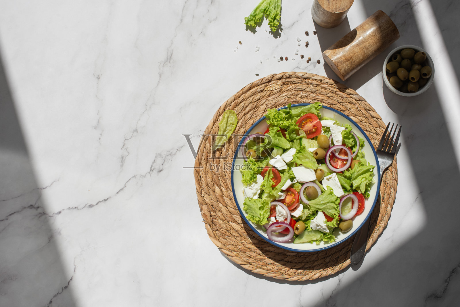 灰色的桌子上放着希腊沙拉、蔬菜和奶酪照片摄影图片