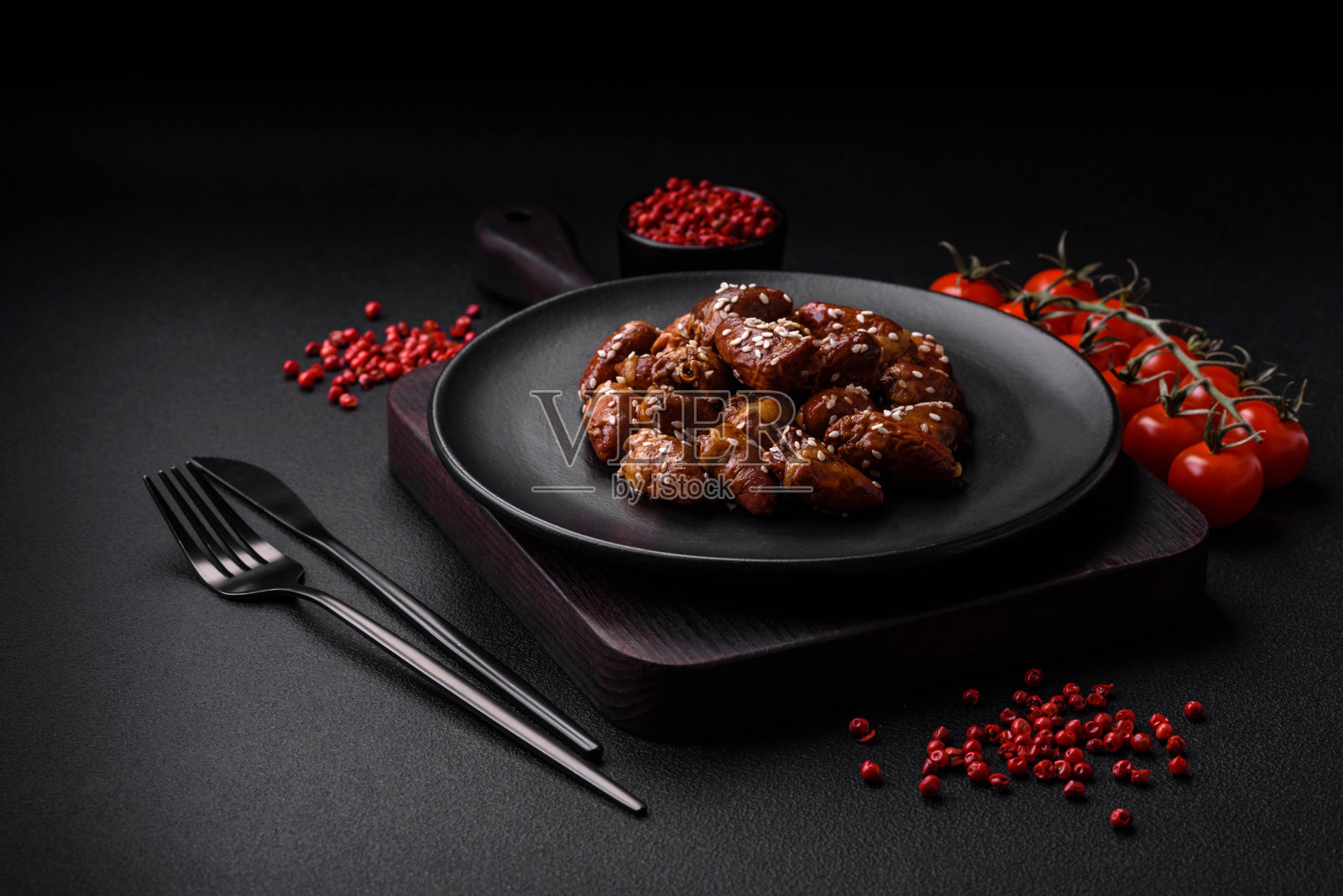 用盐和香料炒鸡心，放在盘子里照片摄影图片