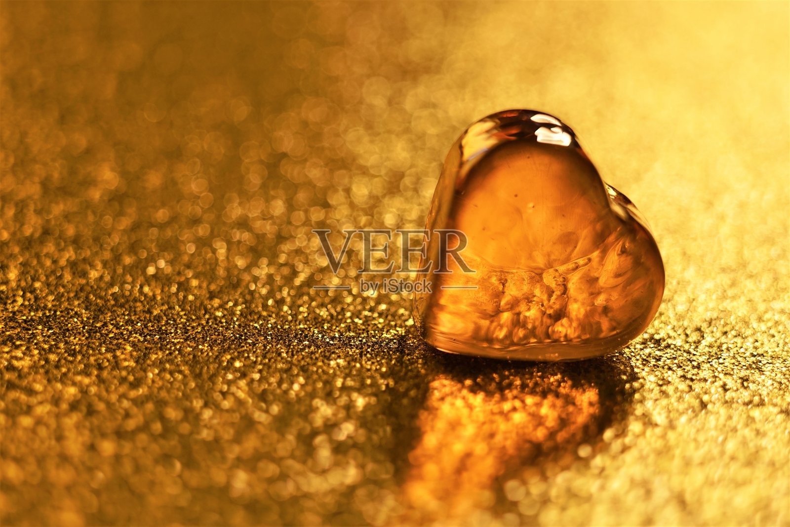金光闪闪的桌子上有琥珀色的玻璃心照片摄影图片