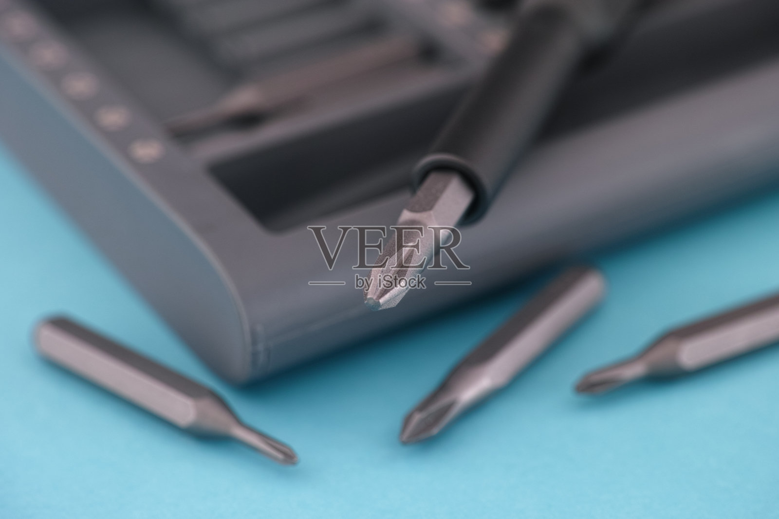 在蓝色表面上放置的螺丝刀钻头照片摄影图片