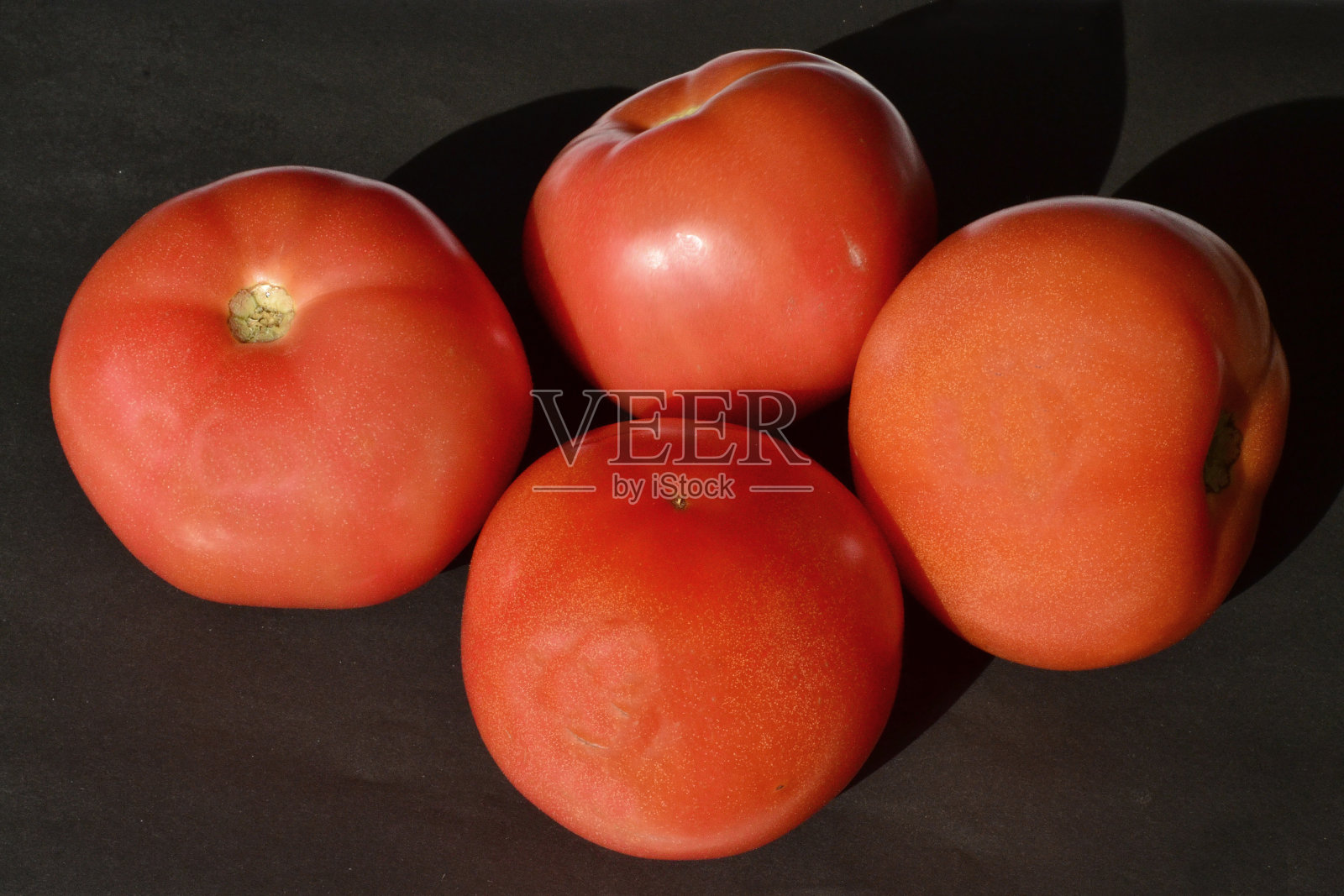 红色的西红柿躺在黑色的背景上照片摄影图片