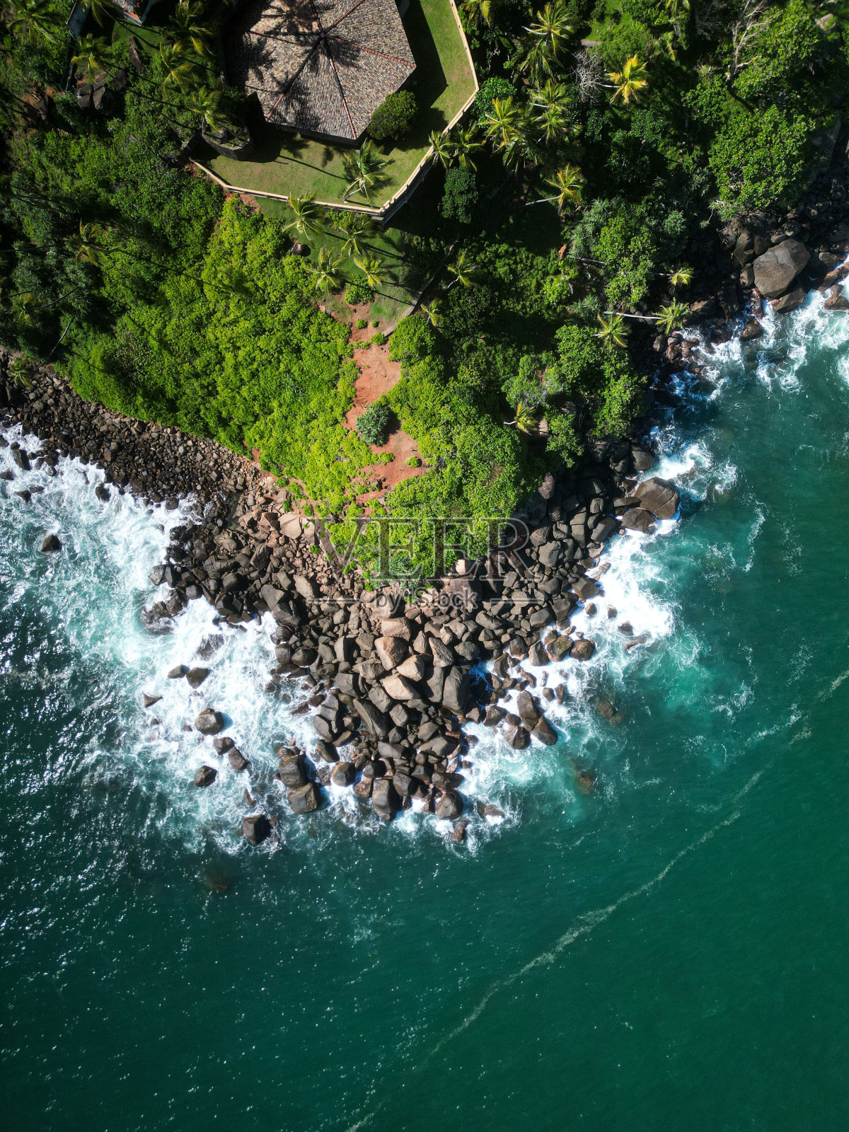 宁静的风景如画的岩石海岸线，郁郁葱葱的绿树照片摄影图片