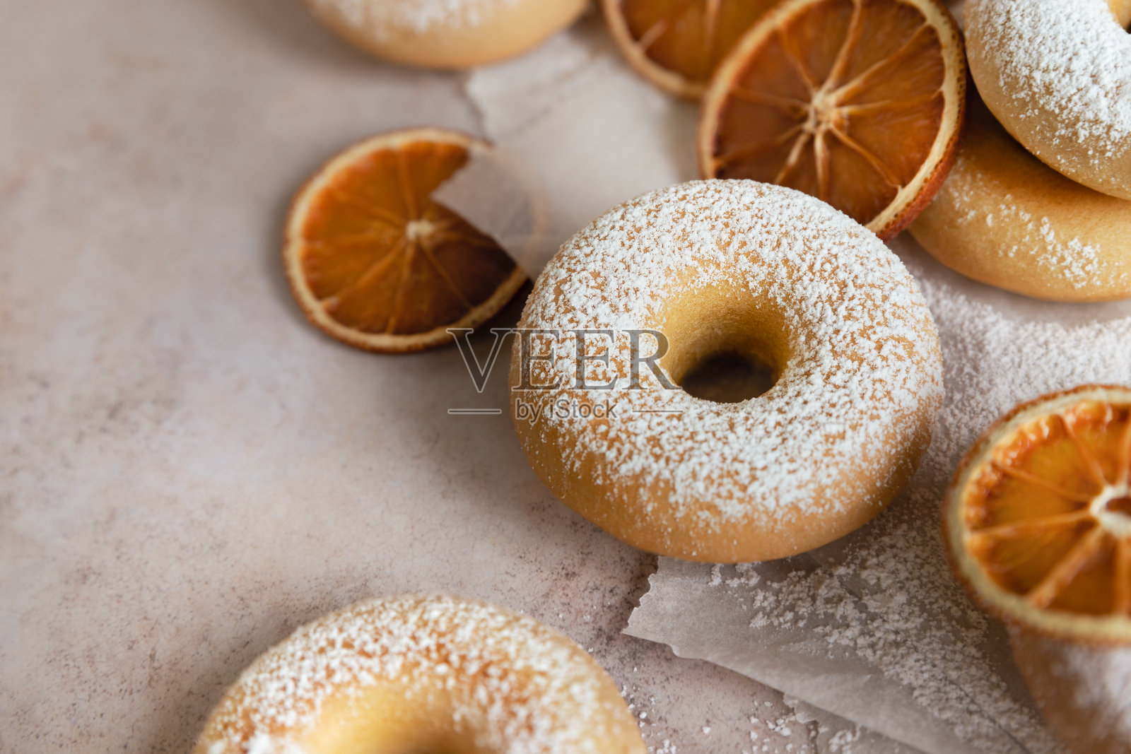 糖粉甜甜圈靠近橙色水果片照片摄影图片