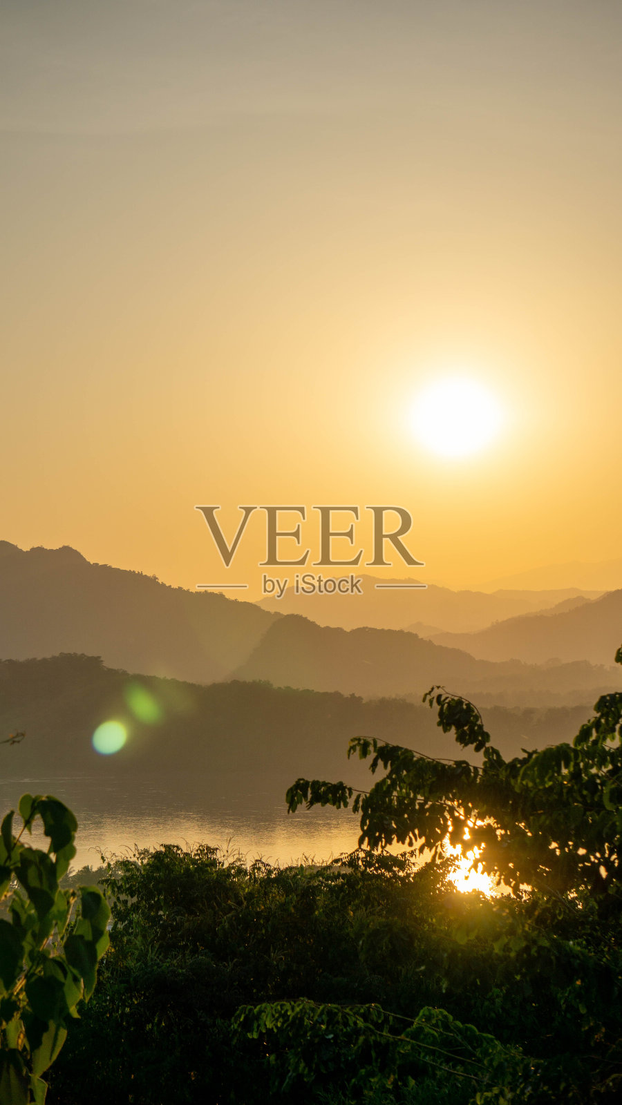 在老挝琅勃拉邦生动的日落期间的山脉景观照片摄影图片