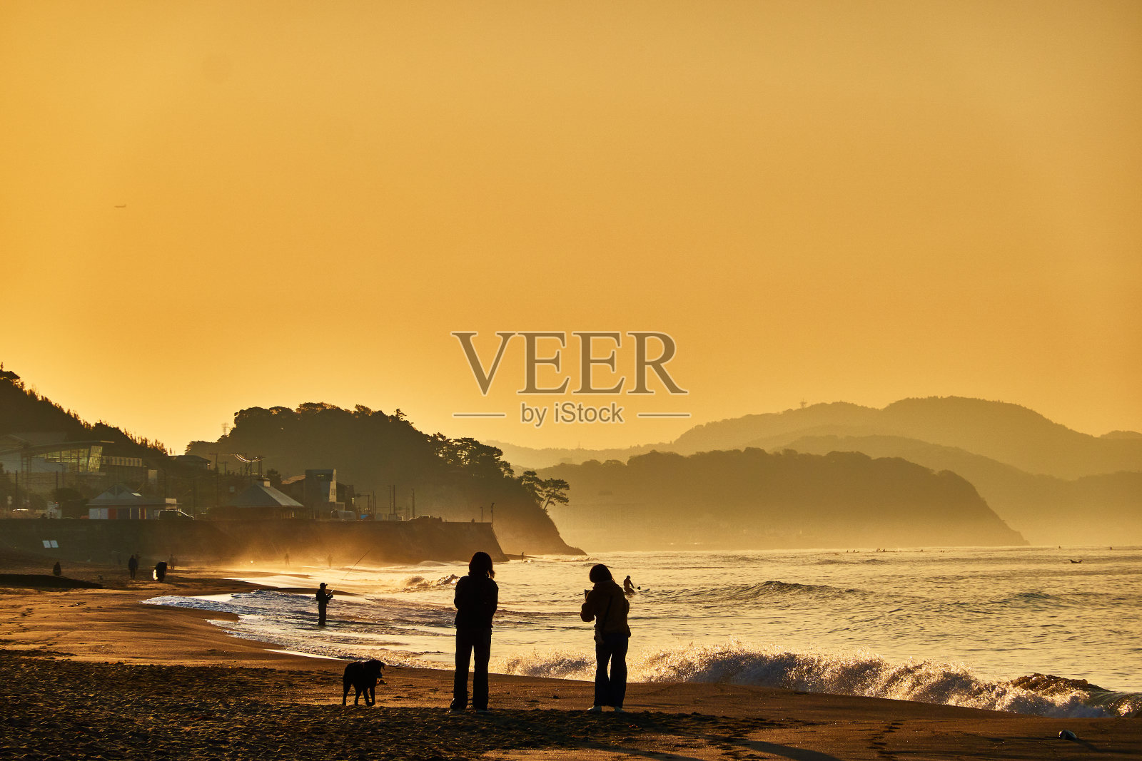 日出时站在海边的人们的剪影照片摄影图片