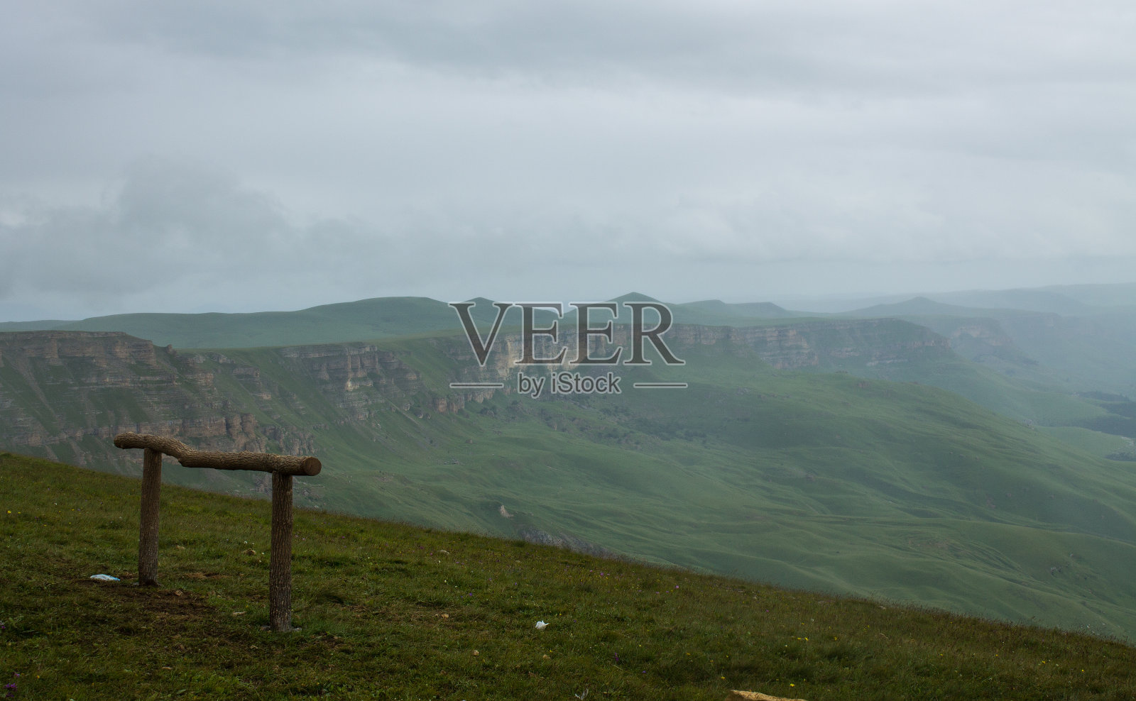 从Bermamyt高原拍摄的柔和焦点，在薄雾中看到山谷和绿色山丘的全景照片摄影图片