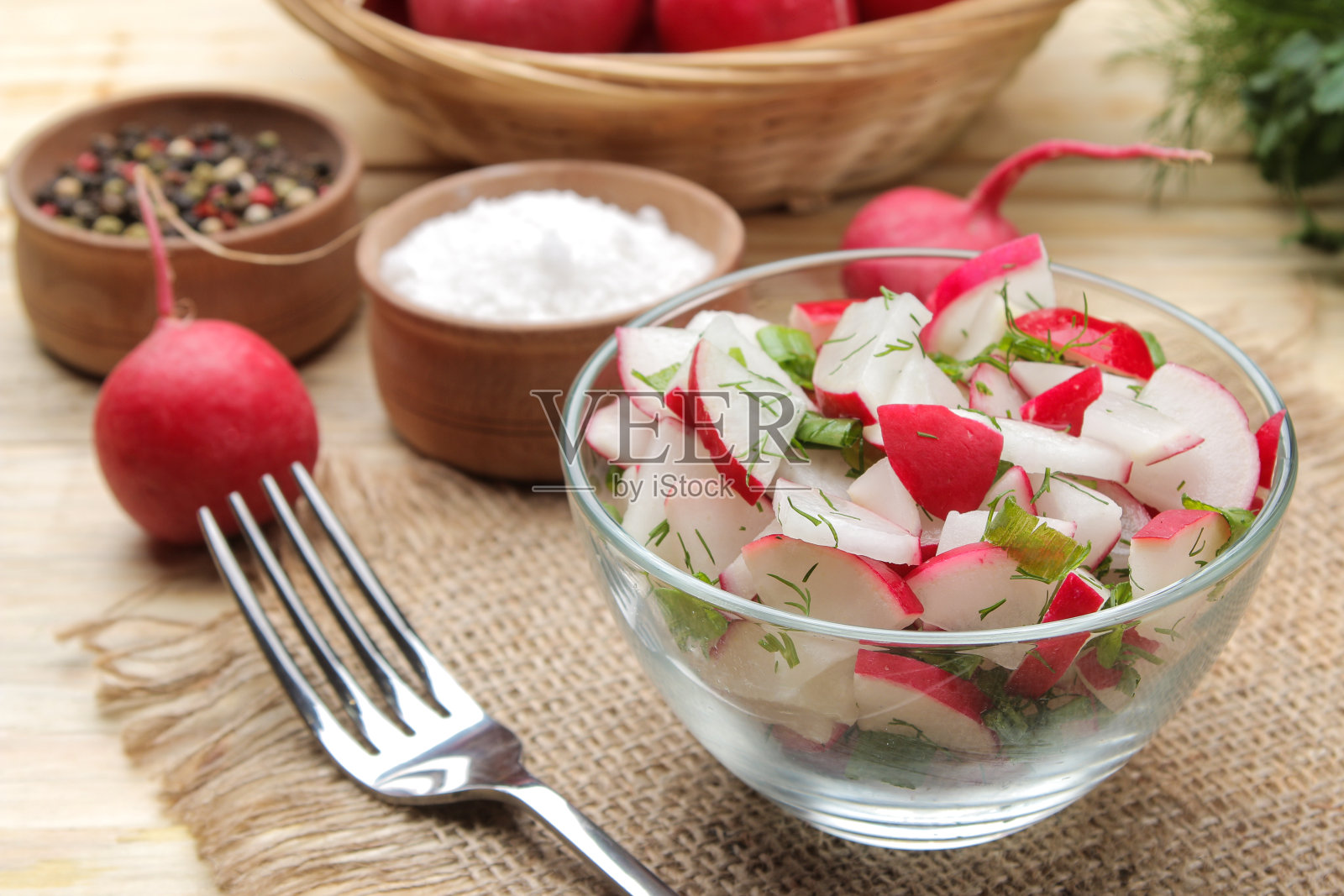 新鲜的萝卜和黄瓜沙拉和蔬菜在一个天然的木桌。春天的蔬菜沙拉。做沙拉的原料。照片摄影图片