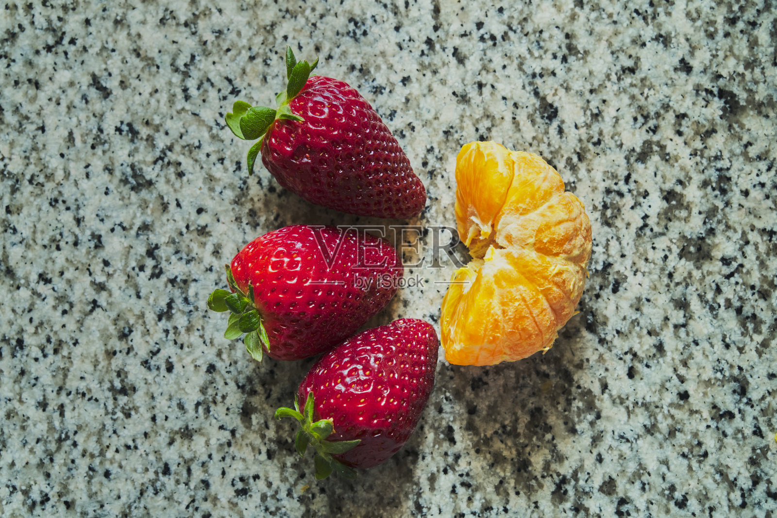 三个草莓和半个橘子照片摄影图片