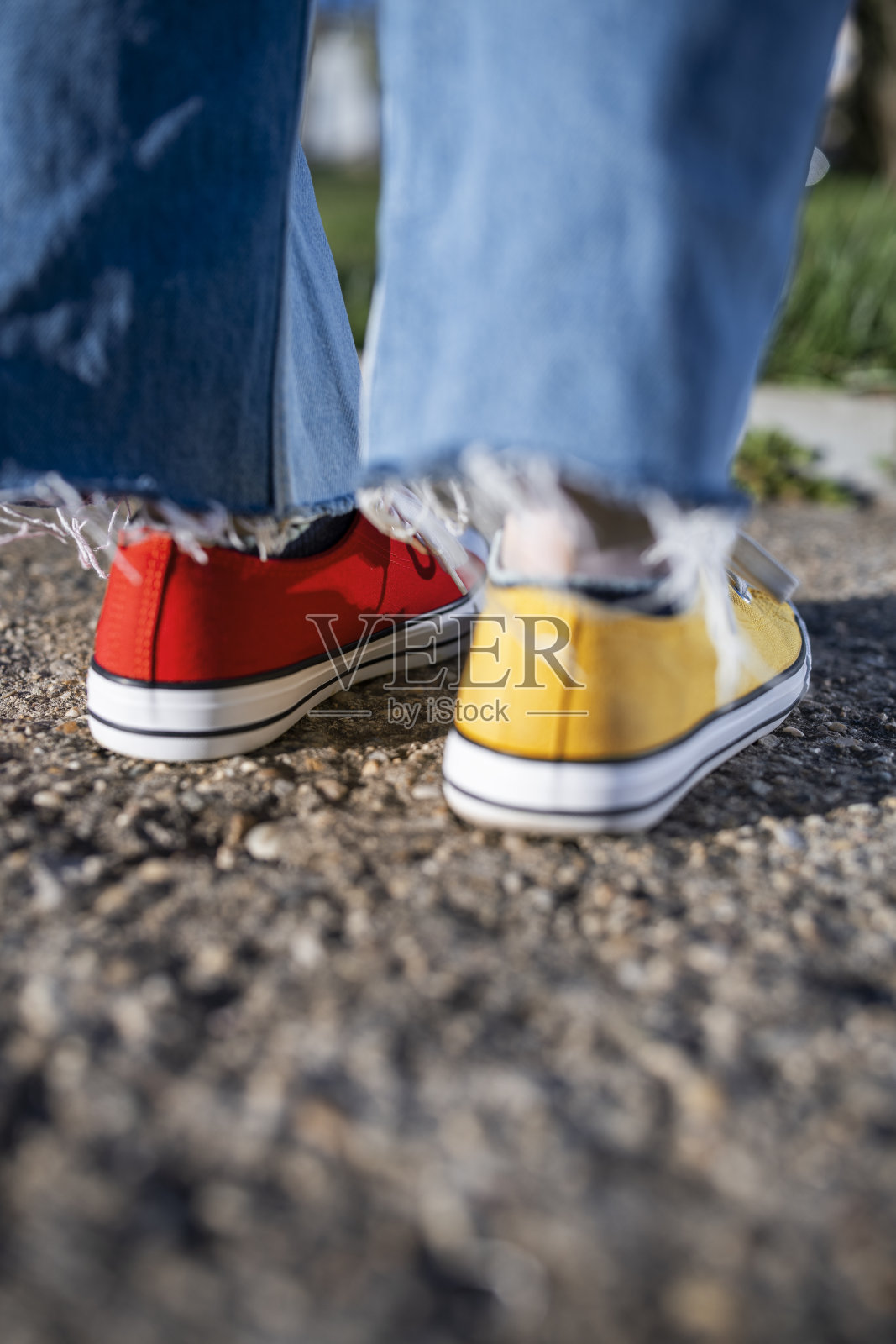 女人穿着红黄相间的帆布鞋。照片摄影图片