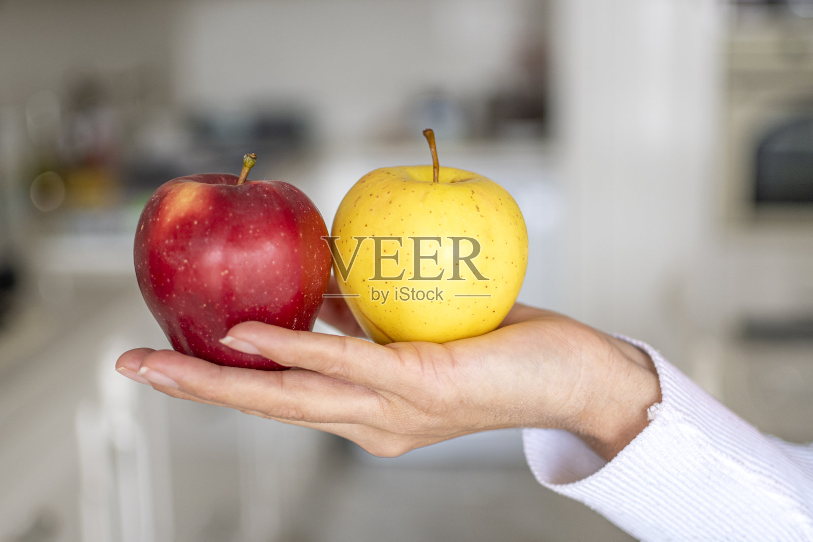 人手中的红苹果和黄苹果照片摄影图片