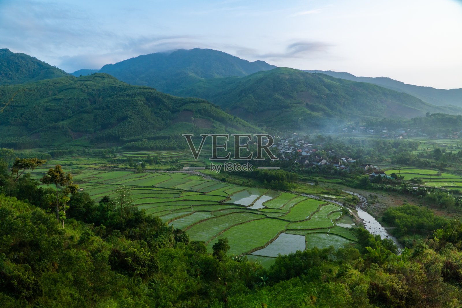 村庄景观有山谷，丘陵和绿色的森林，早上很少有露水照片摄影图片