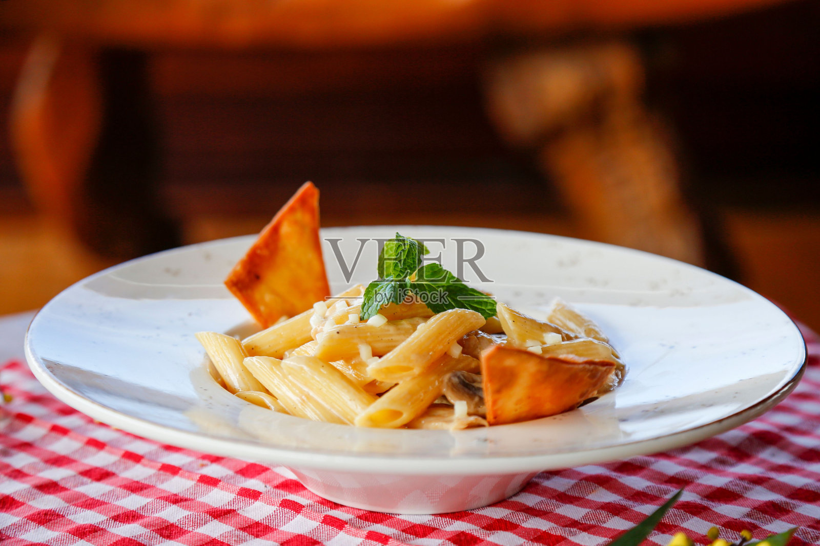 一盘美味的意大利面，上面有西红柿丁、融化的奶酪和香料照片摄影图片