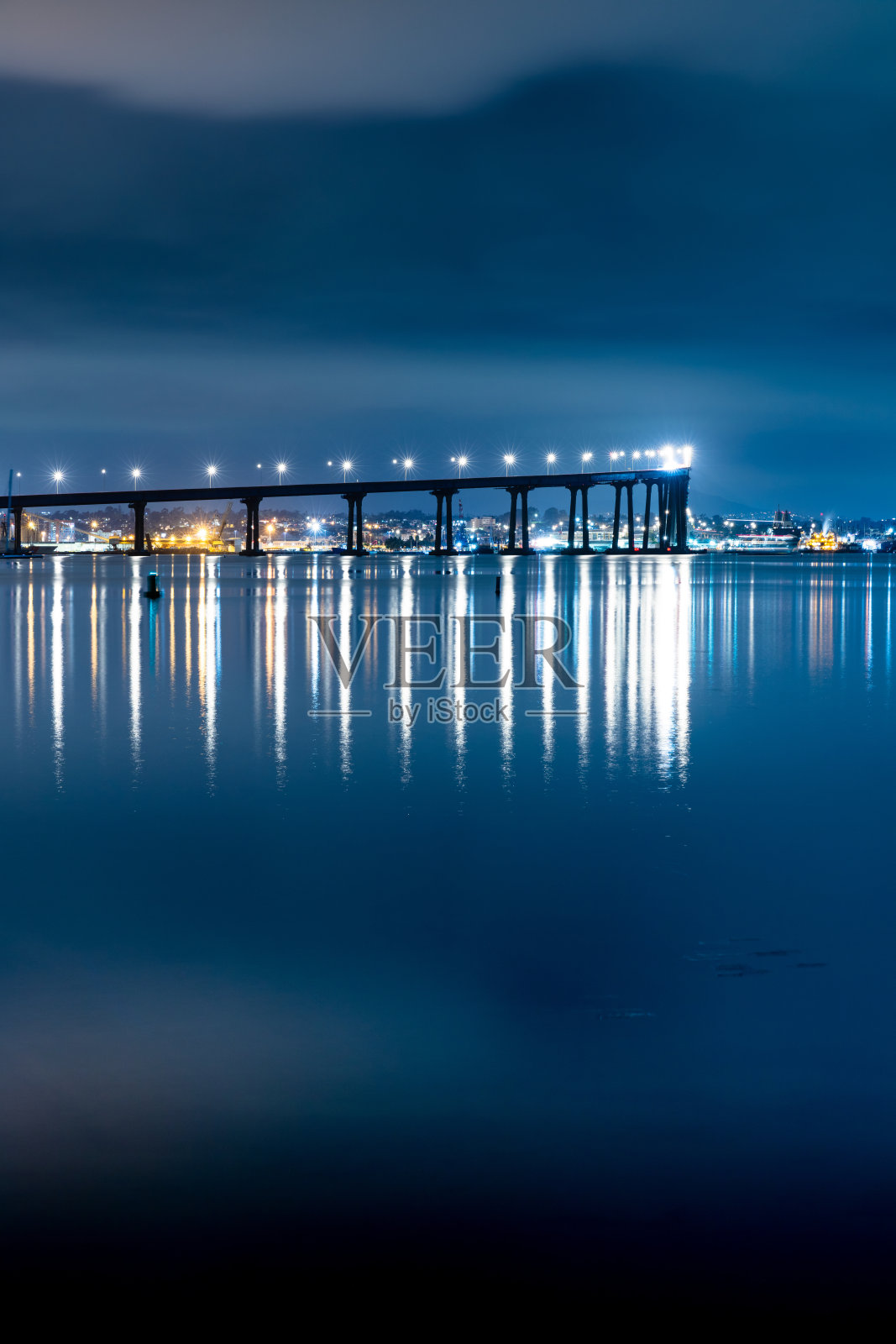 科罗纳多大桥在夜晚以圣地亚哥市中心为背景的垂直拍摄照片摄影图片