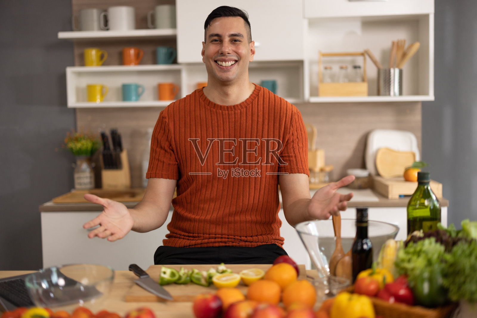 一位相貌平平、身体健康的男性准备了营养丰富的饮食，包括各种水果。掌握水果的削皮、切碎和切片，以艺术的方式准备它们。照片摄影图片