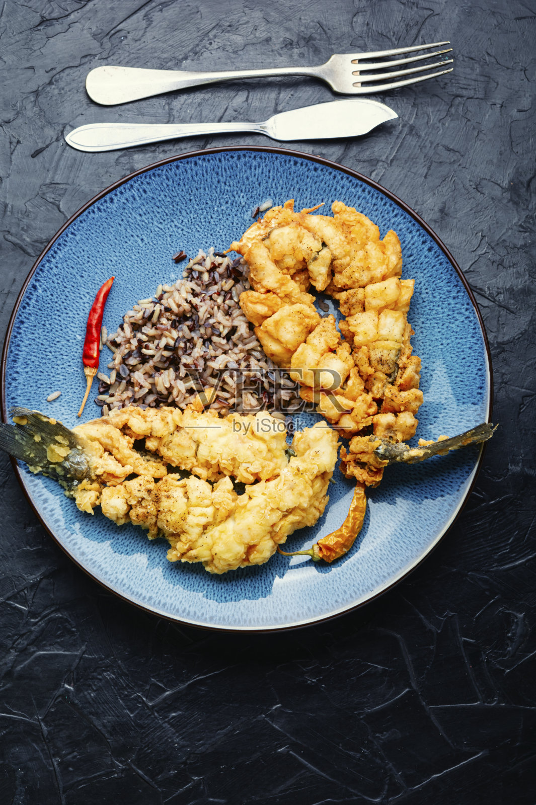 盘子里有面包屑鱼和米饭。照片摄影图片