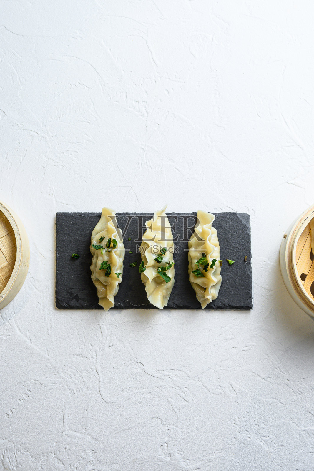 近景:刚煮熟的日本饺子，黑色石板上涂着酱油照片摄影图片