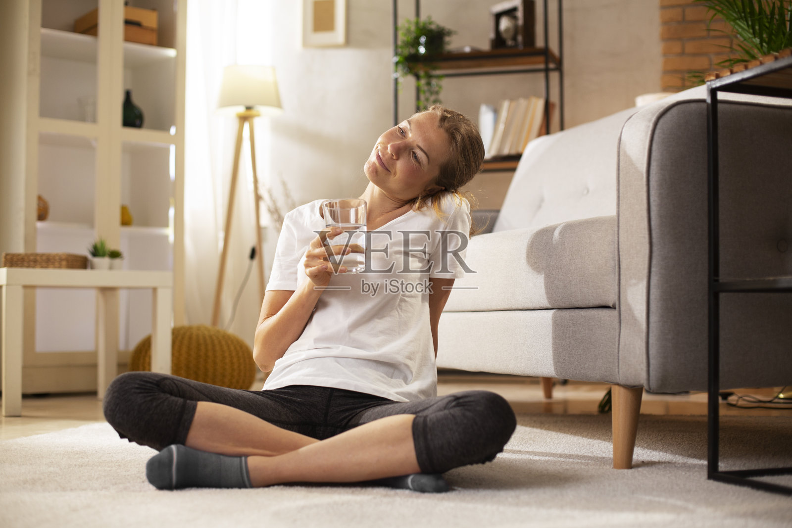 微笑的女人在喝水。照片摄影图片