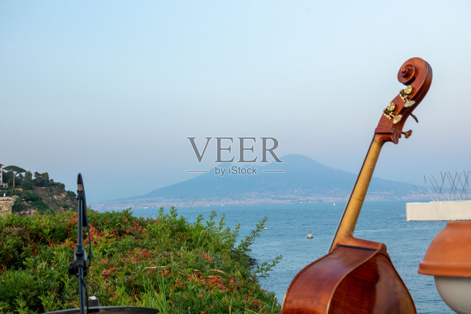 以那不勒斯湾维苏威火山为背景的低音提琴照片摄影图片