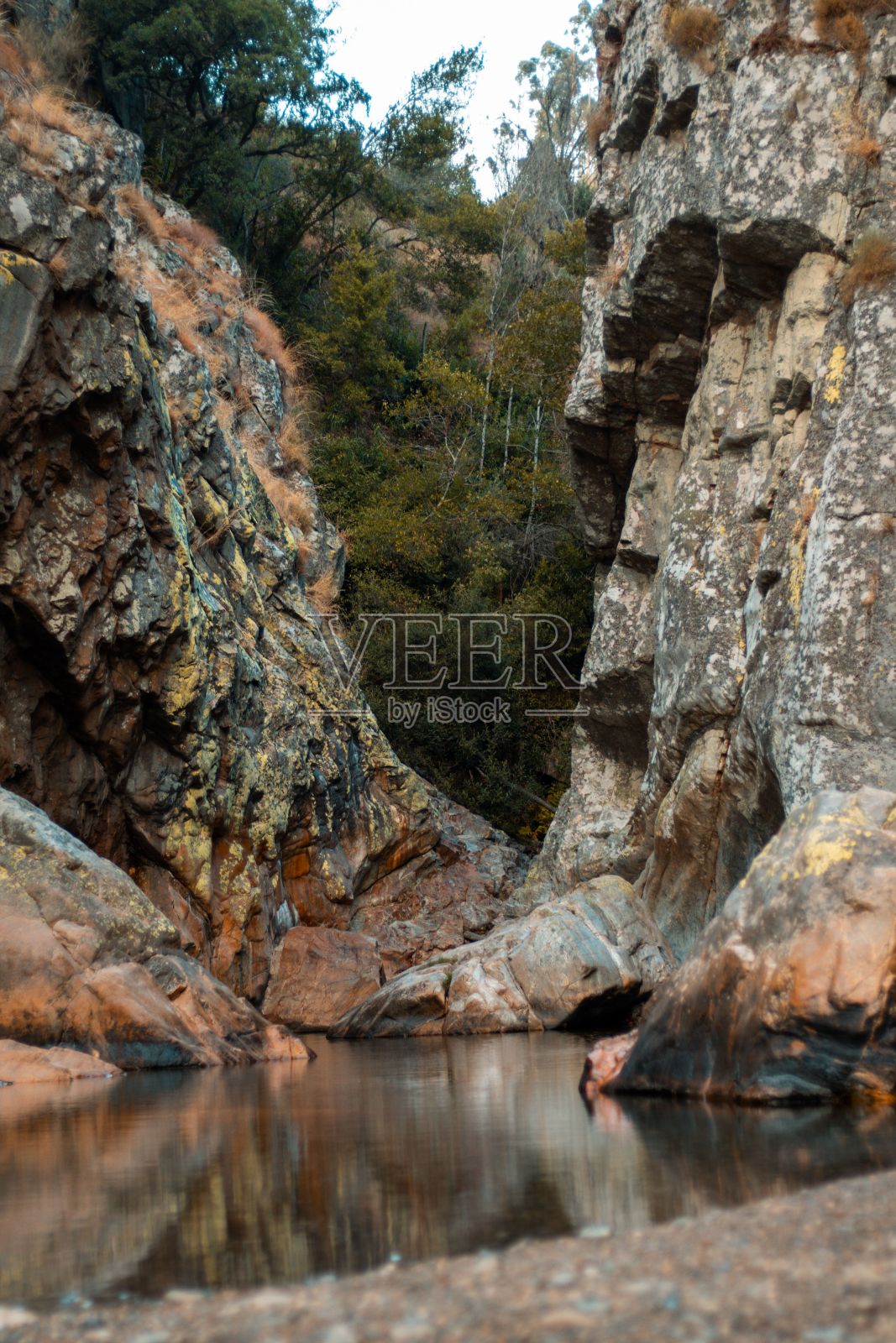 背景中有一条河，旁边是一些大岩石和树木照片摄影图片