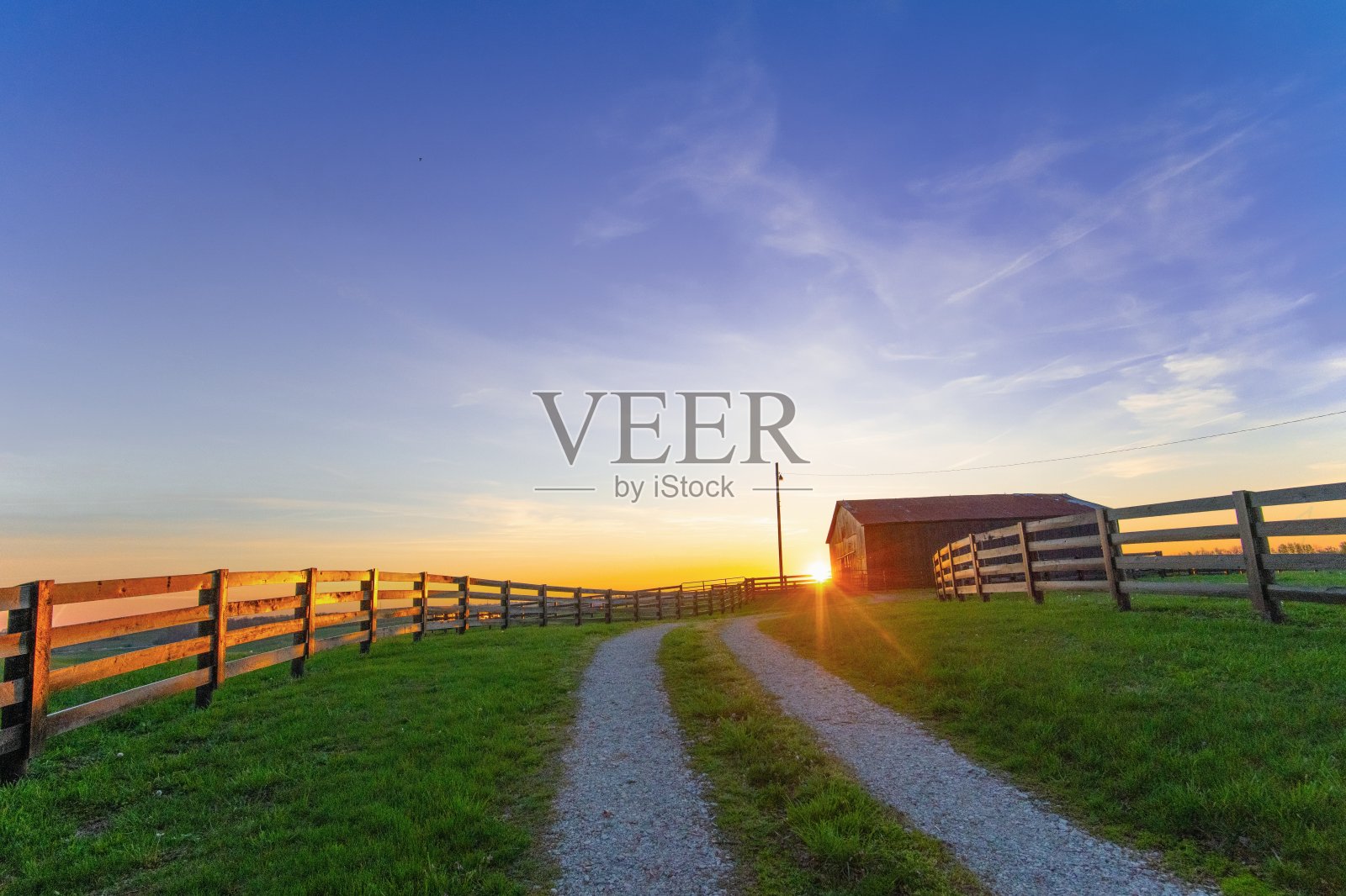 日出与一条车道的道路，烟草谷仓和围栏-近里士满，肯塔基州照片摄影图片