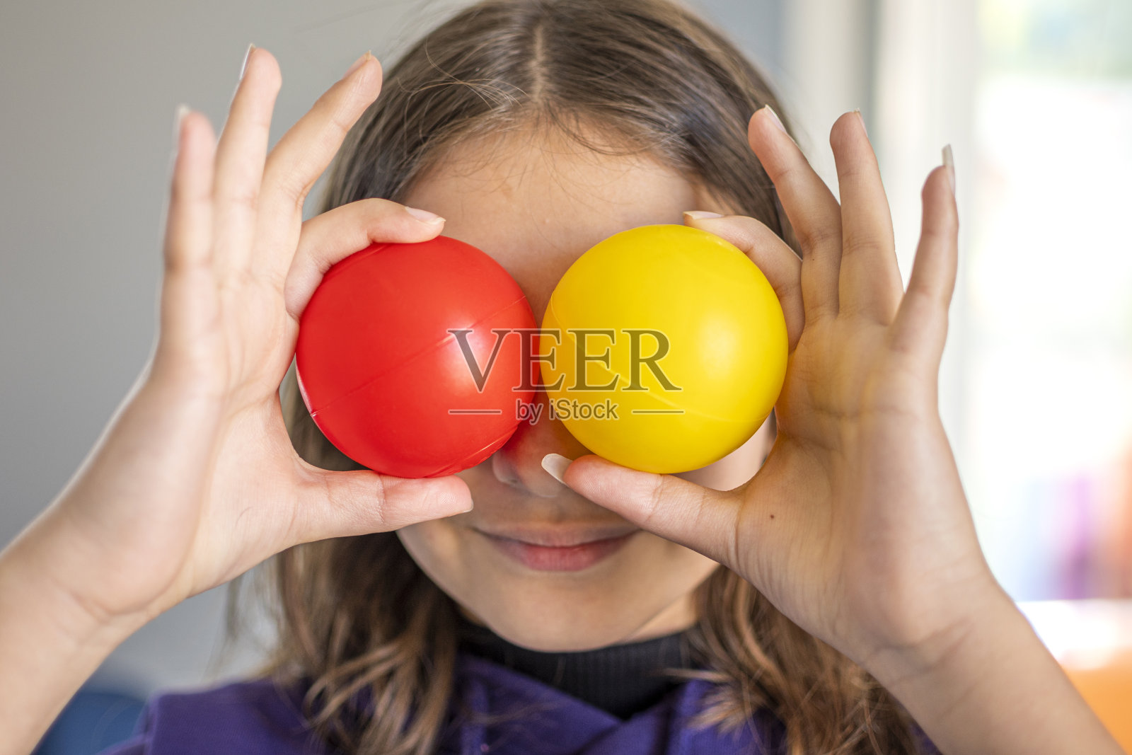 手里拿着红、黄两个球照片摄影图片