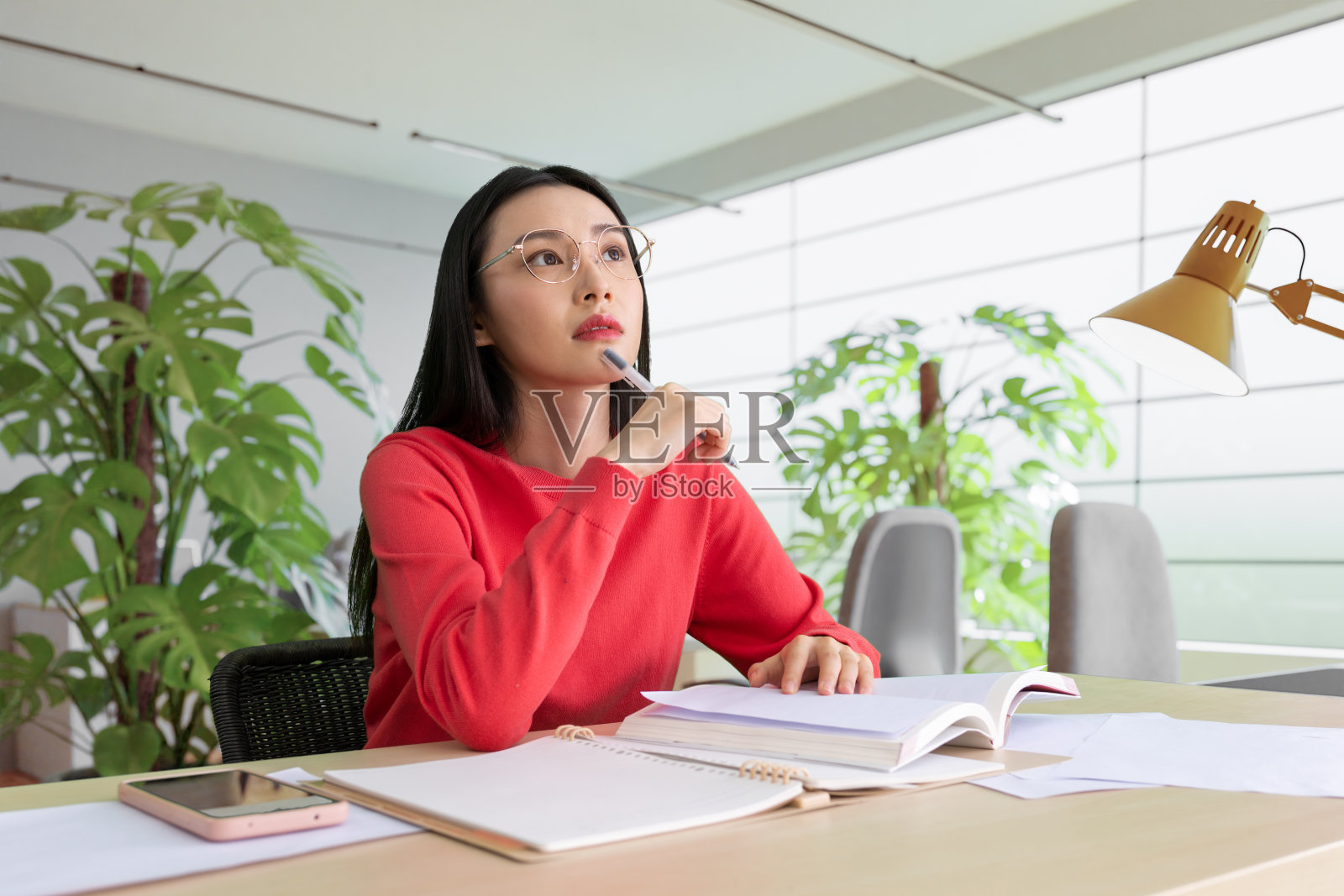 咖啡店里，女人用铅笔在笔记本上写字。在咖啡店户外工作的妇女。照片摄影图片