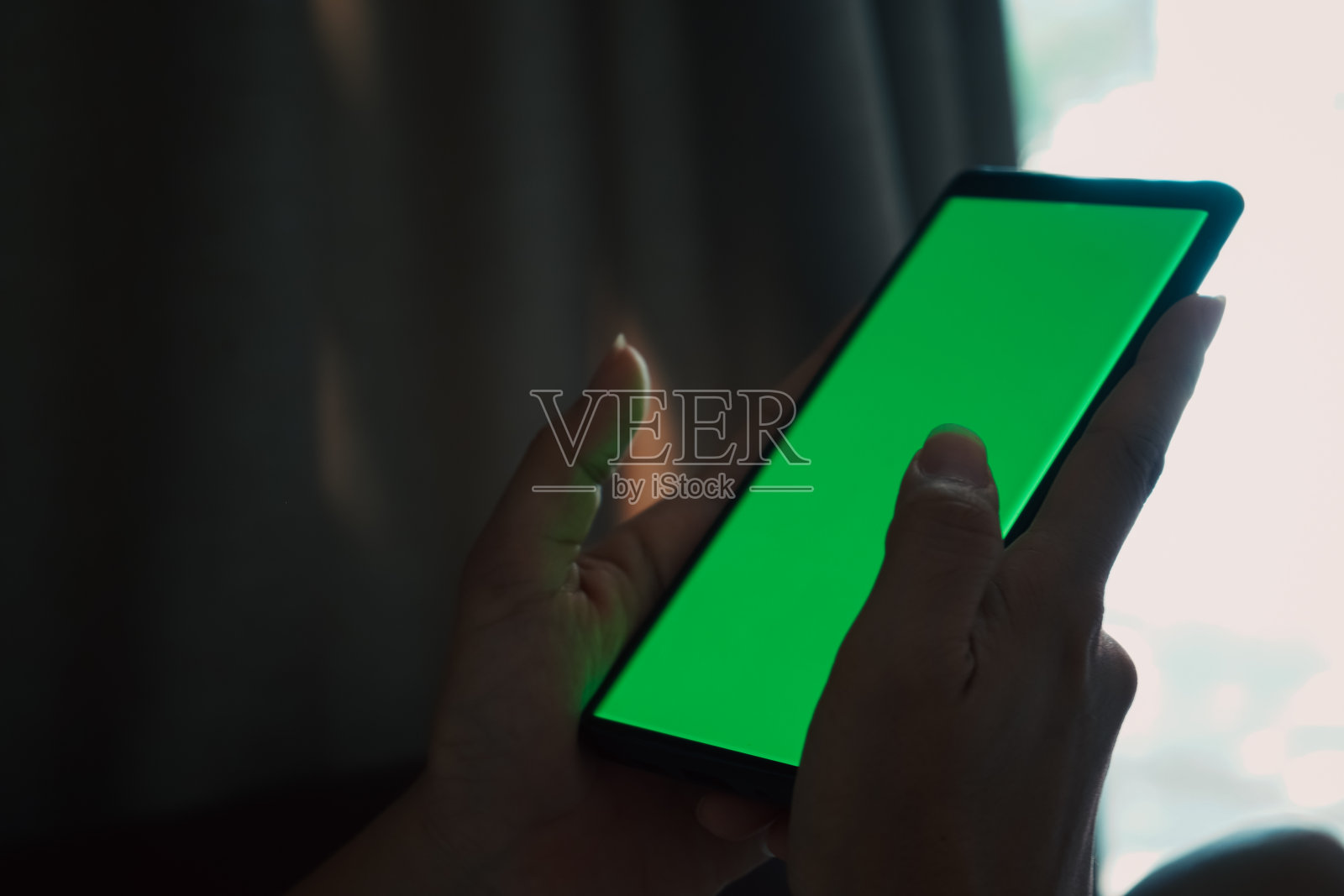 手持绿屏手机照片摄影图片