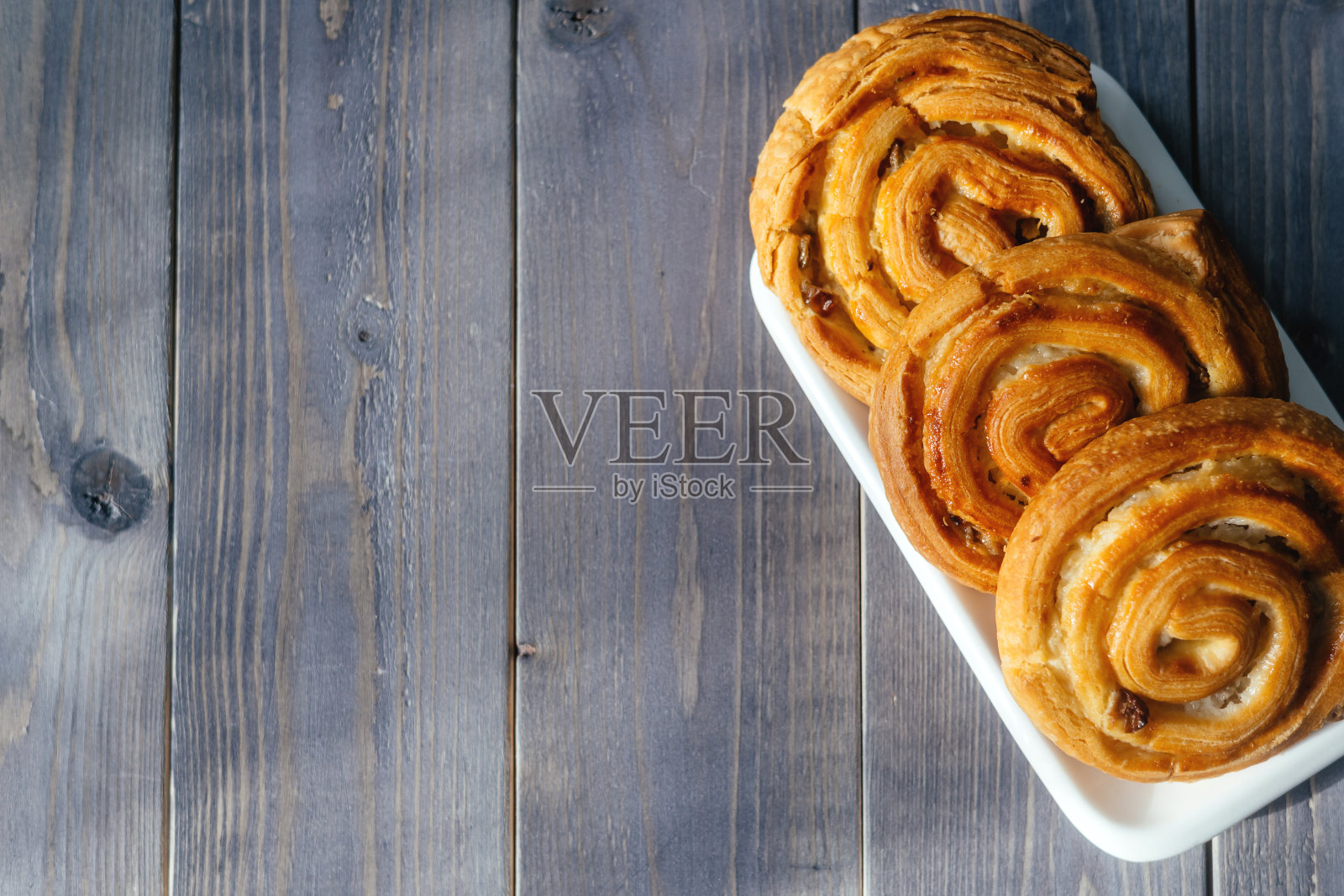 木制背景上的面包。白天休息一下，与朋友和家人边喝咖啡边吃蛋糕聊天。照片摄影图片