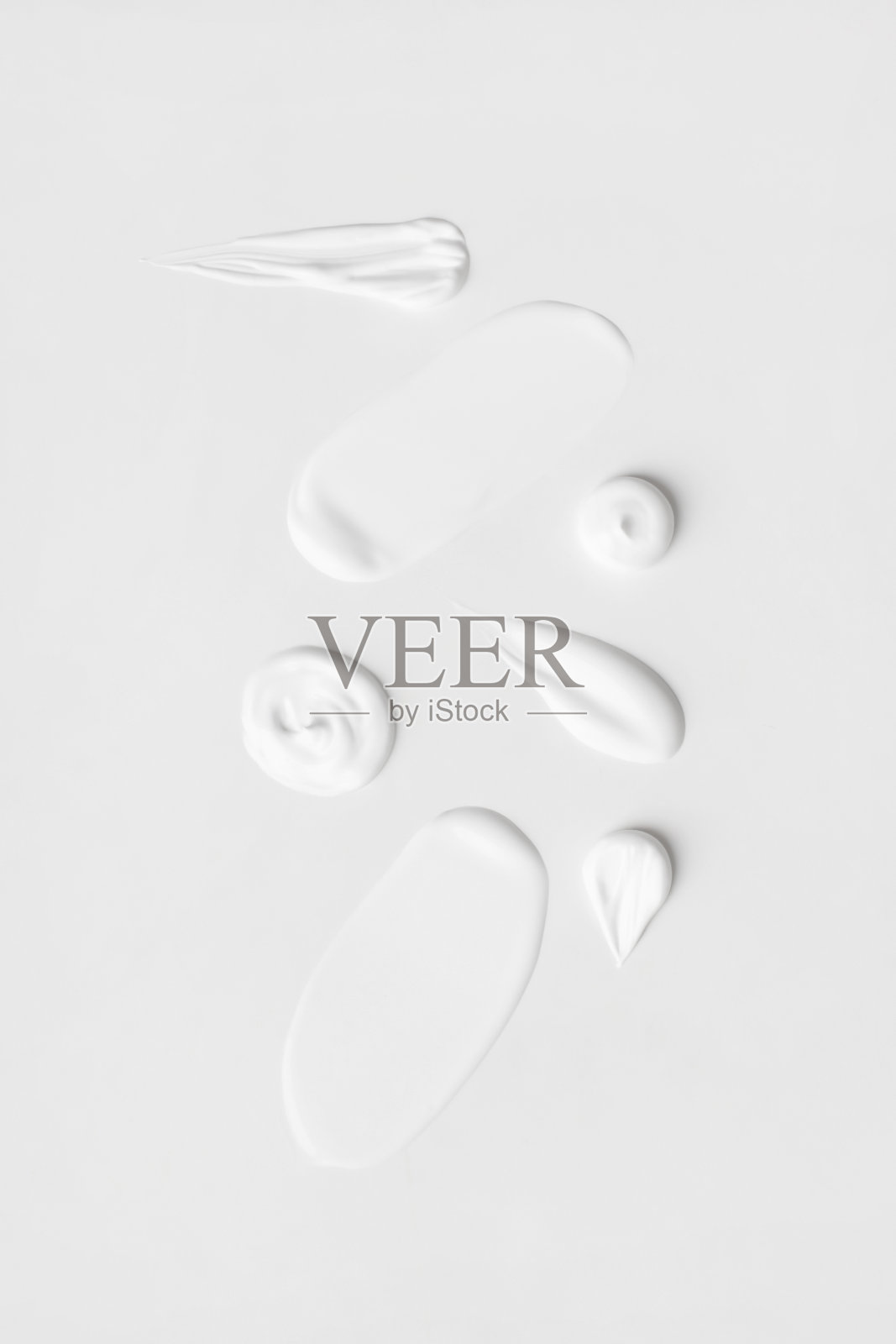 浅色背景上一组不同笔触的白色奶油。照片摄影图片