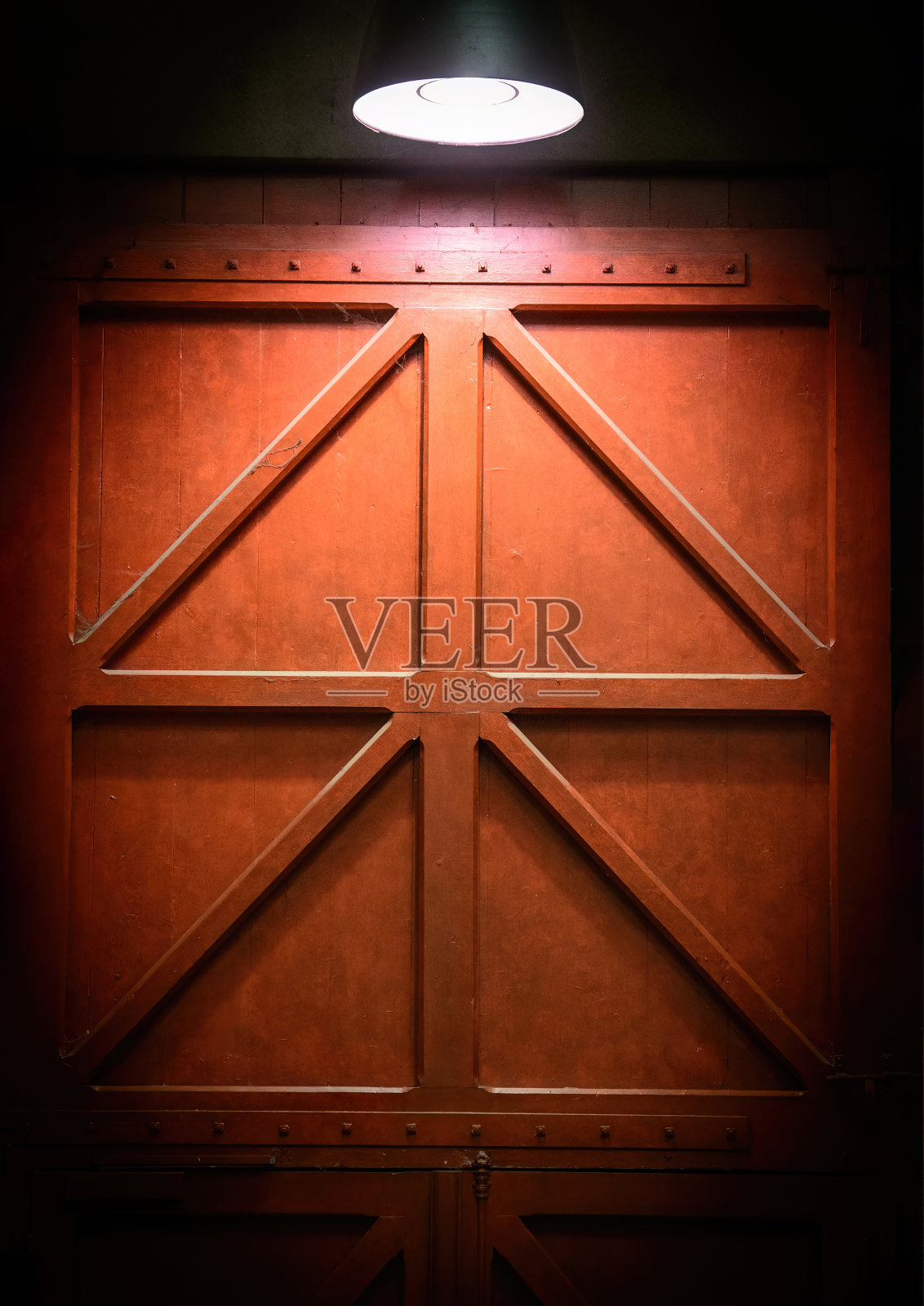 红色坚固的门，上面有光。照片摄影图片