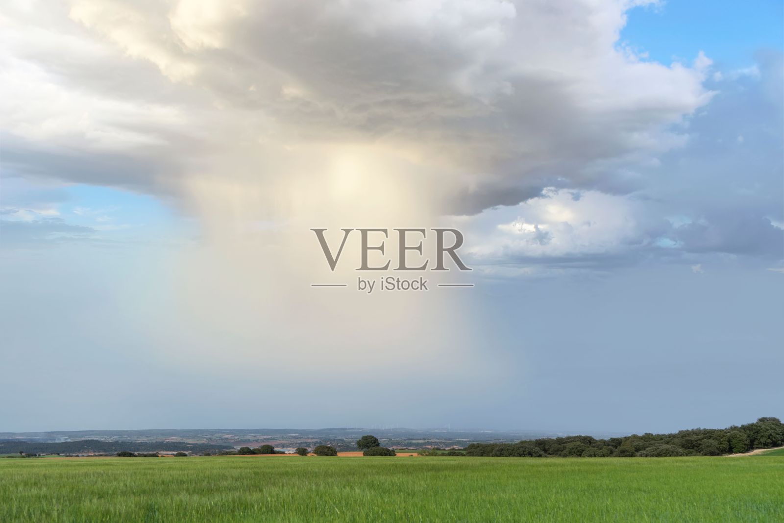 壮观的景观绿色的田野与雨幕从风暴的云。照片摄影图片